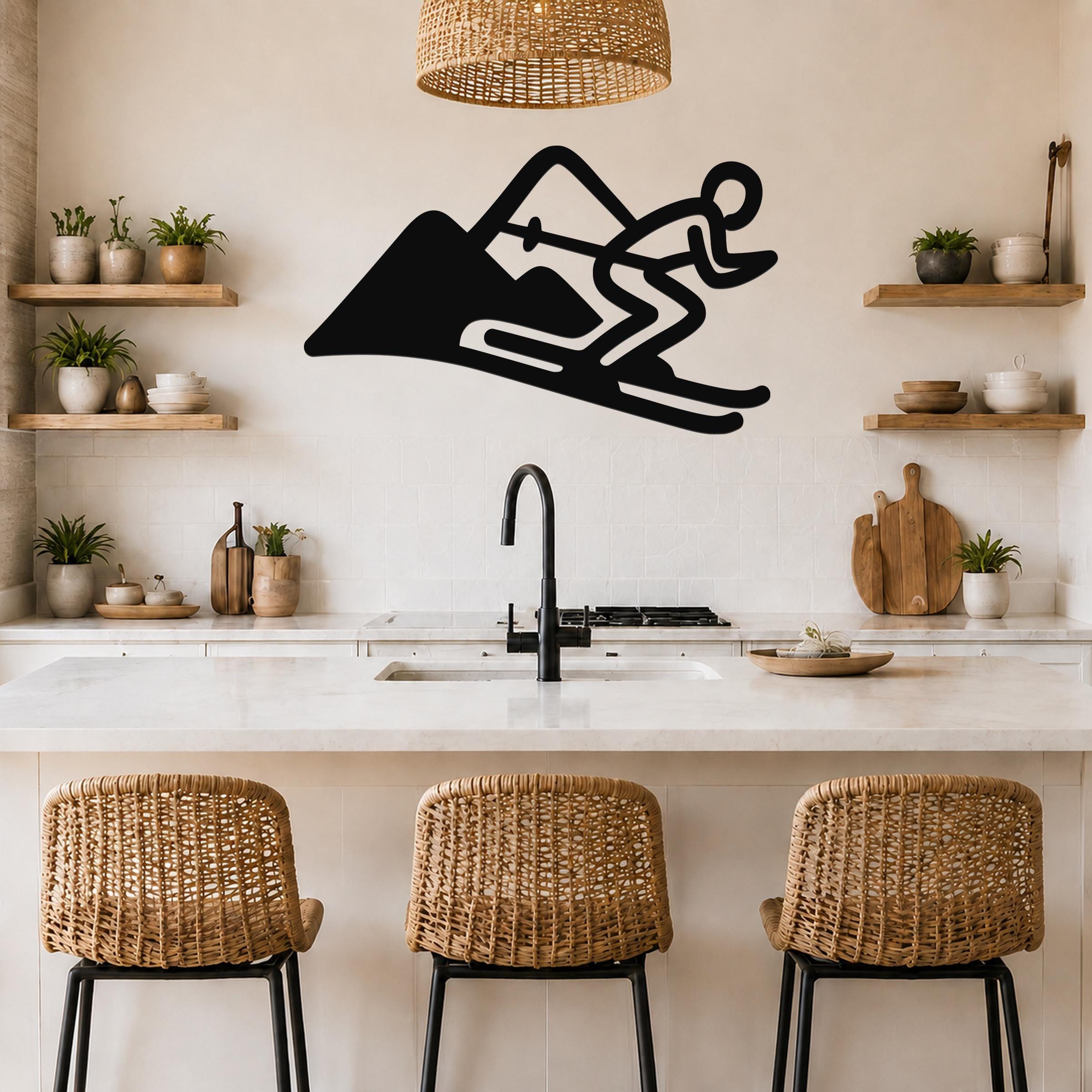 Black metal wall art featuring a skier silhouette in motion on a mountain, mounted above a kitchen counter with wicker bar stools.
