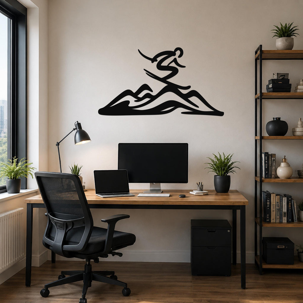 Black metal wall art featuring a skier silhouette above a mountain, mounted on a wall above a wooden desk in a home office.
