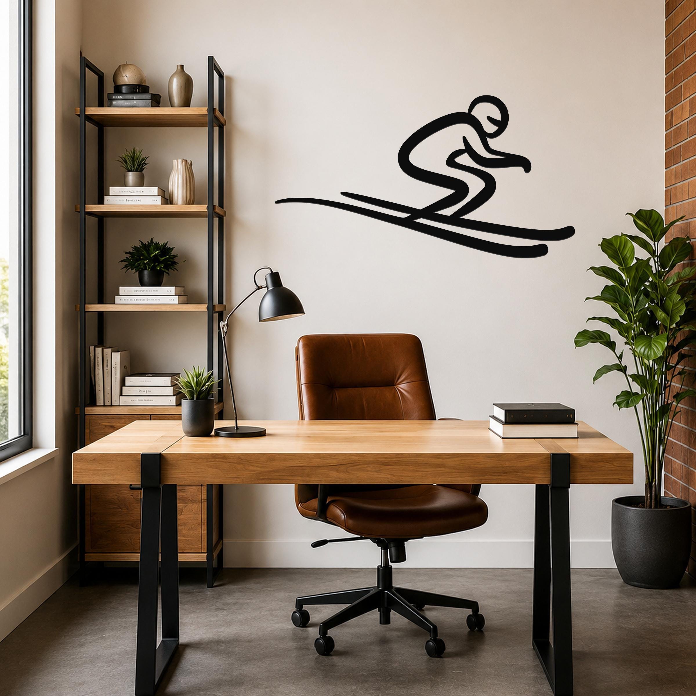 Black metal skier wall art with motion-line cutouts, mounted above a wooden desk in a modern home office.