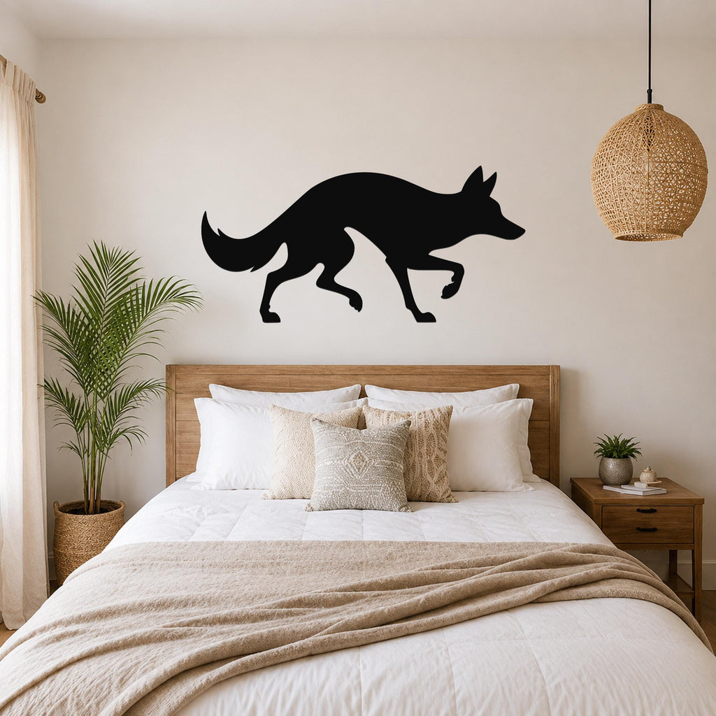 Black metal coyote silhouette wall art mounted above a wooden bed in a neutral bedroom.