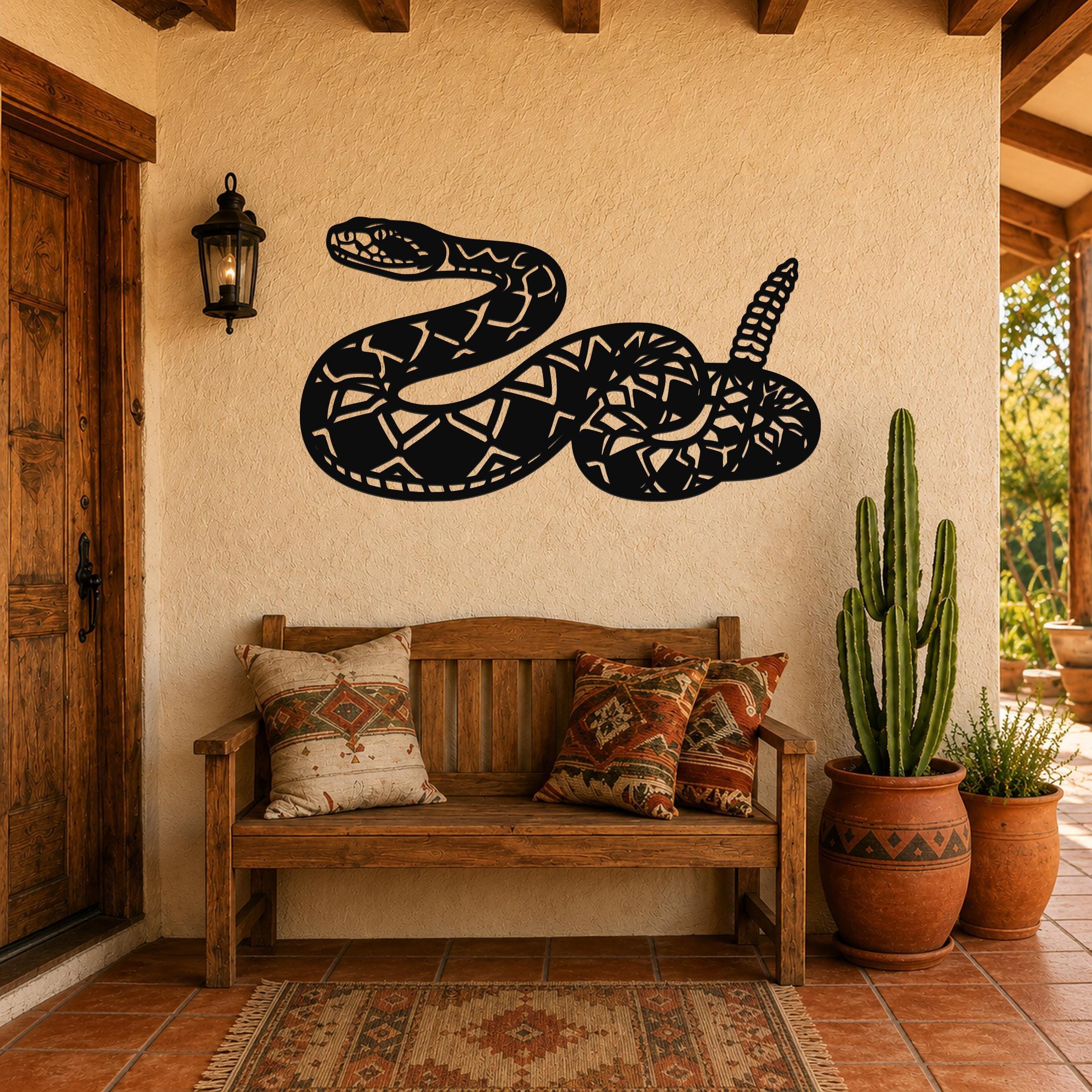 Black metal snake wall art with geometric cutout patterns, mounted on a stucco wall above a wooden bench in a rustic patio entryway.