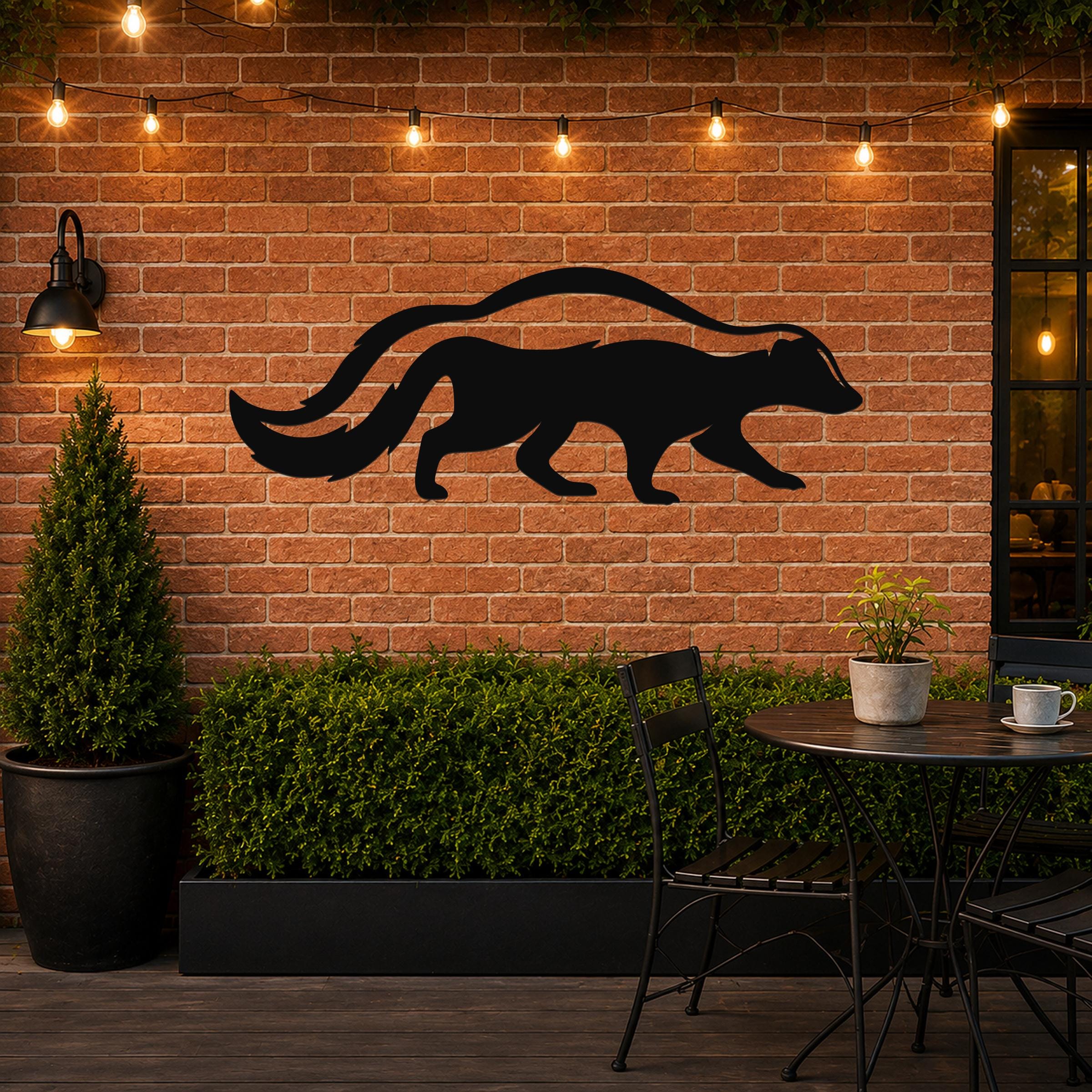Black metal skunk wall art silhouette with a long curved tail, mounted on a brick patio wall above a small table and greenery.