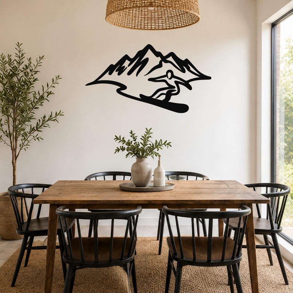 Black metal wall sculpture of a snowboarder in silhouette, mounted on a dining room wall above a wooden table.