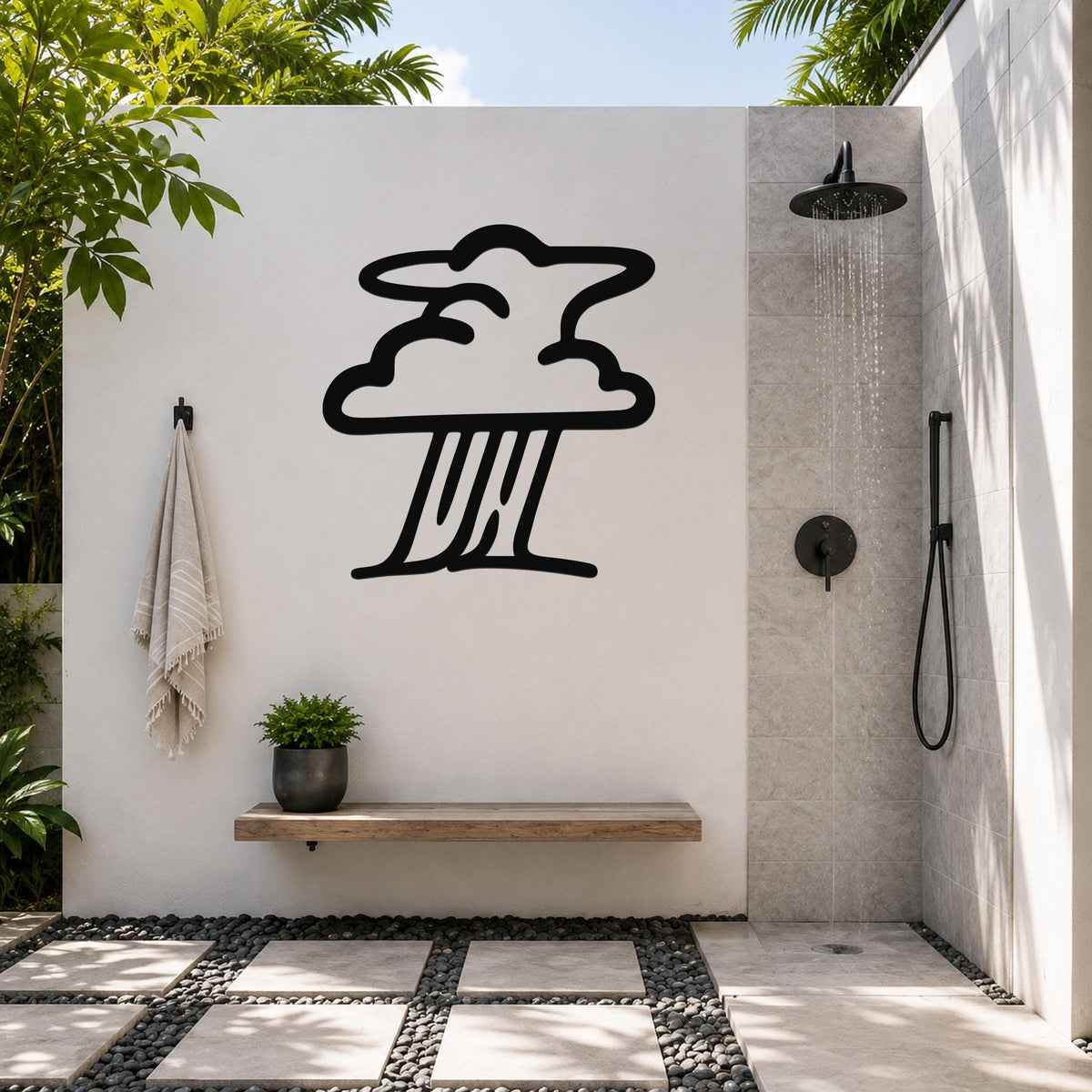 Black metal storm cloud wall art silhouette mounted on a white outdoor shower wall, above a wooden bench with a potted plant, in a tropical patio setting.