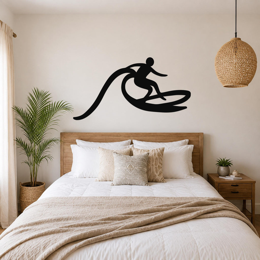 Black metal surfer wall art with a wave motion cutout, mounted above a wooden bed in a neutral bedroom.