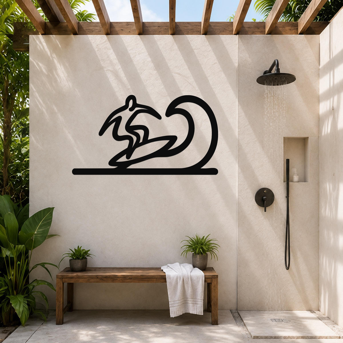 Black metal surfer wall art with a wave silhouette, mounted on a beige outdoor shower wall above a wooden bench.