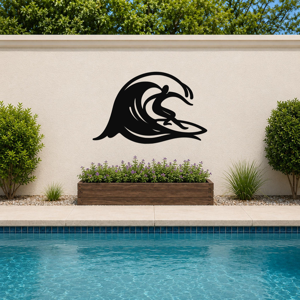 Black metal wall art in a surfer riding a wave silhouette, mounted on an outdoor wall above a planter and pool.