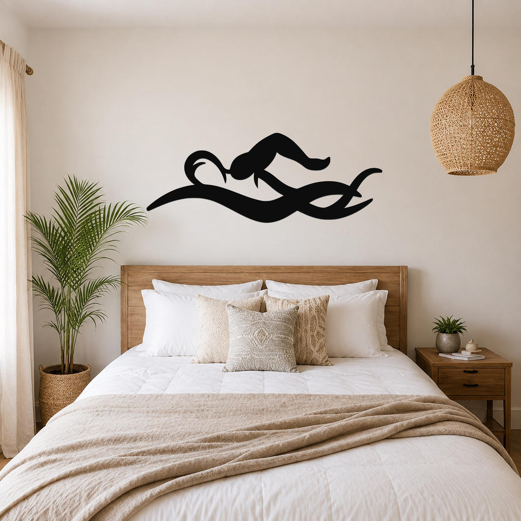 Black metal swimmer wall art with fluid motion cutouts, mounted above a wooden bed in a neutral bedroom.