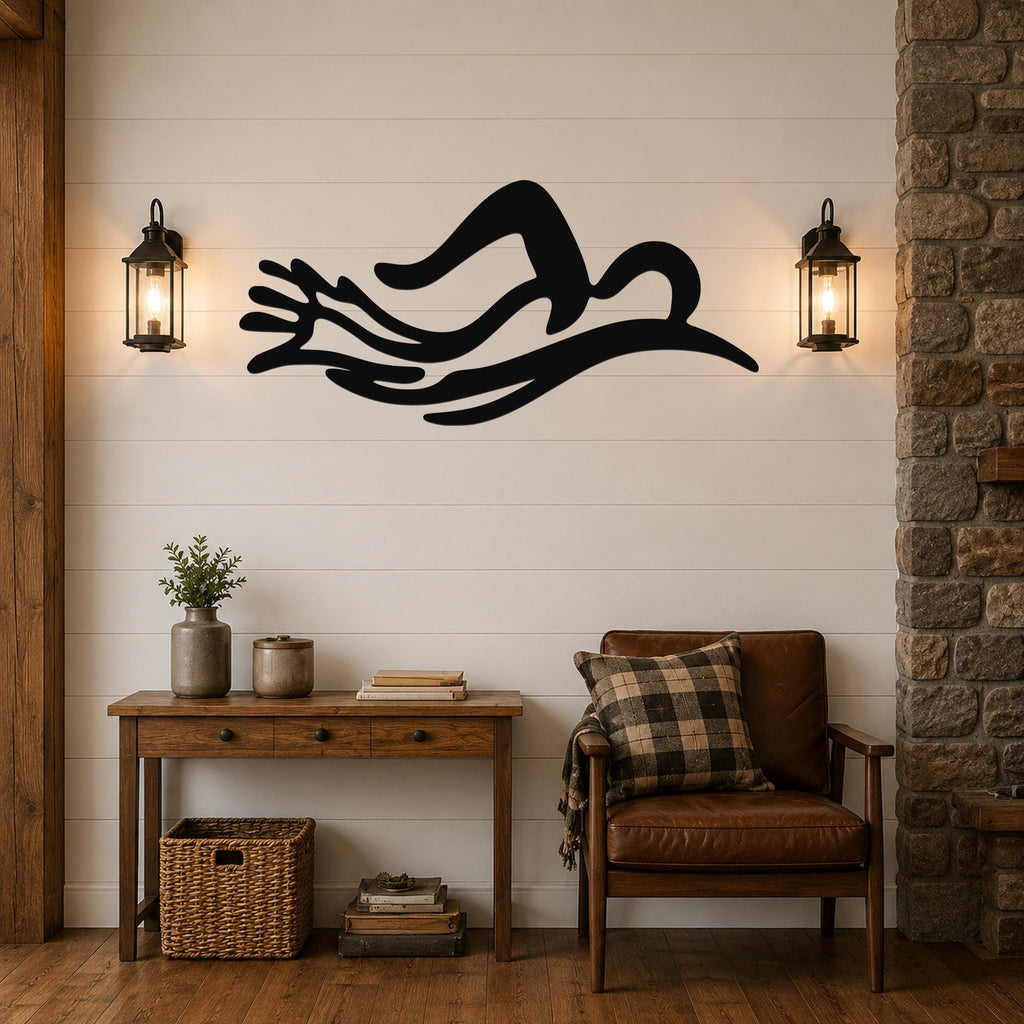 Black metal wall art in the silhouette of a swimmer in motion, mounted above a wooden console table in a living room.