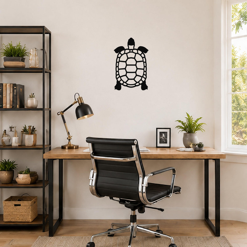 Black metal tortoise wall art with a cutout shell design, mounted on a wall above a wooden desk in a home office.