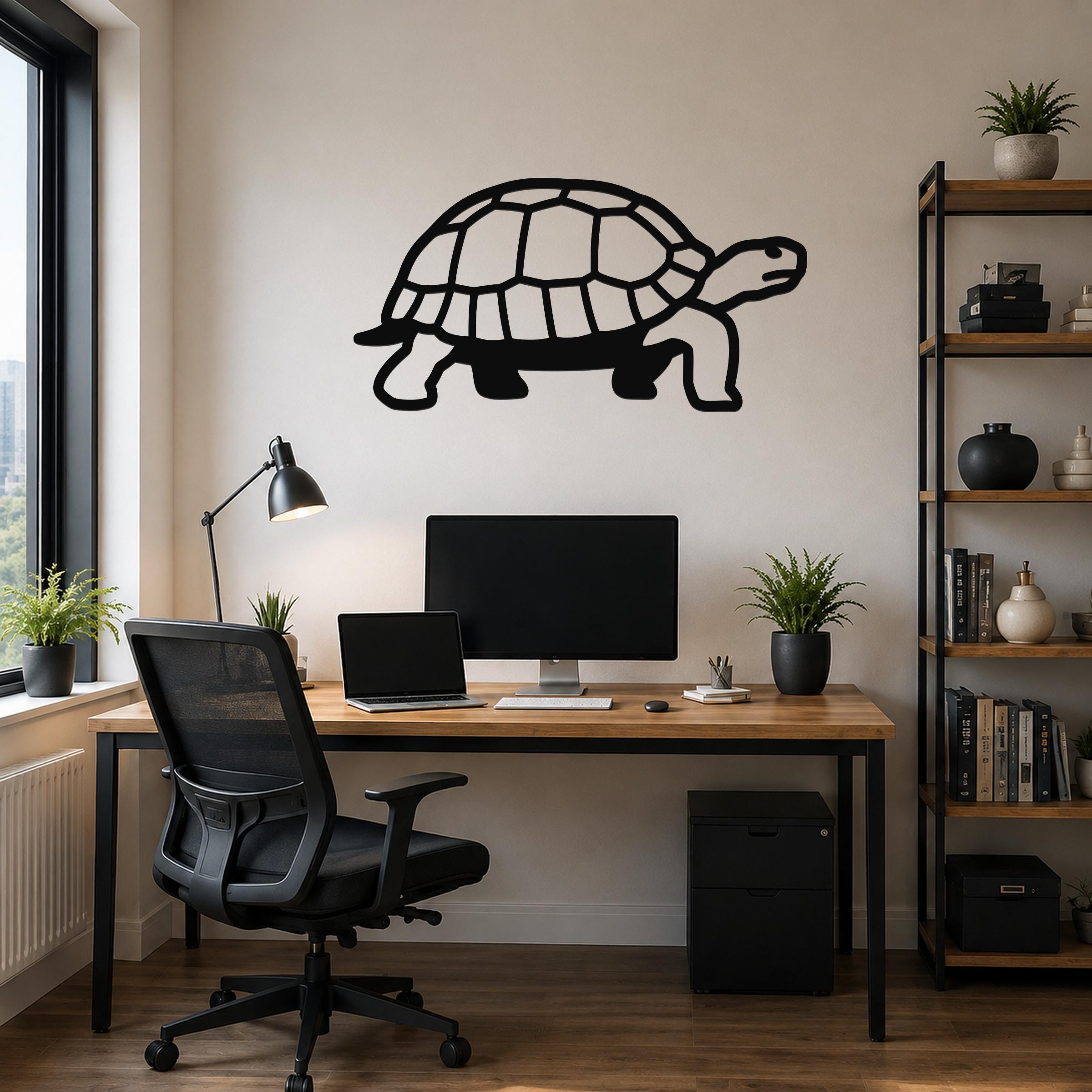 Black metal tortoise wall art with detailed shell cutouts, mounted on a light-colored wall above a wooden desk in a home office.