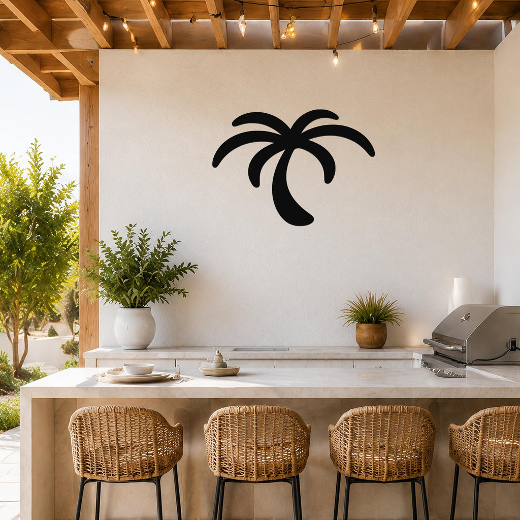 Black metal palm tree wall art with curved frond cutouts, mounted on a white outdoor kitchen wall above a counter.
