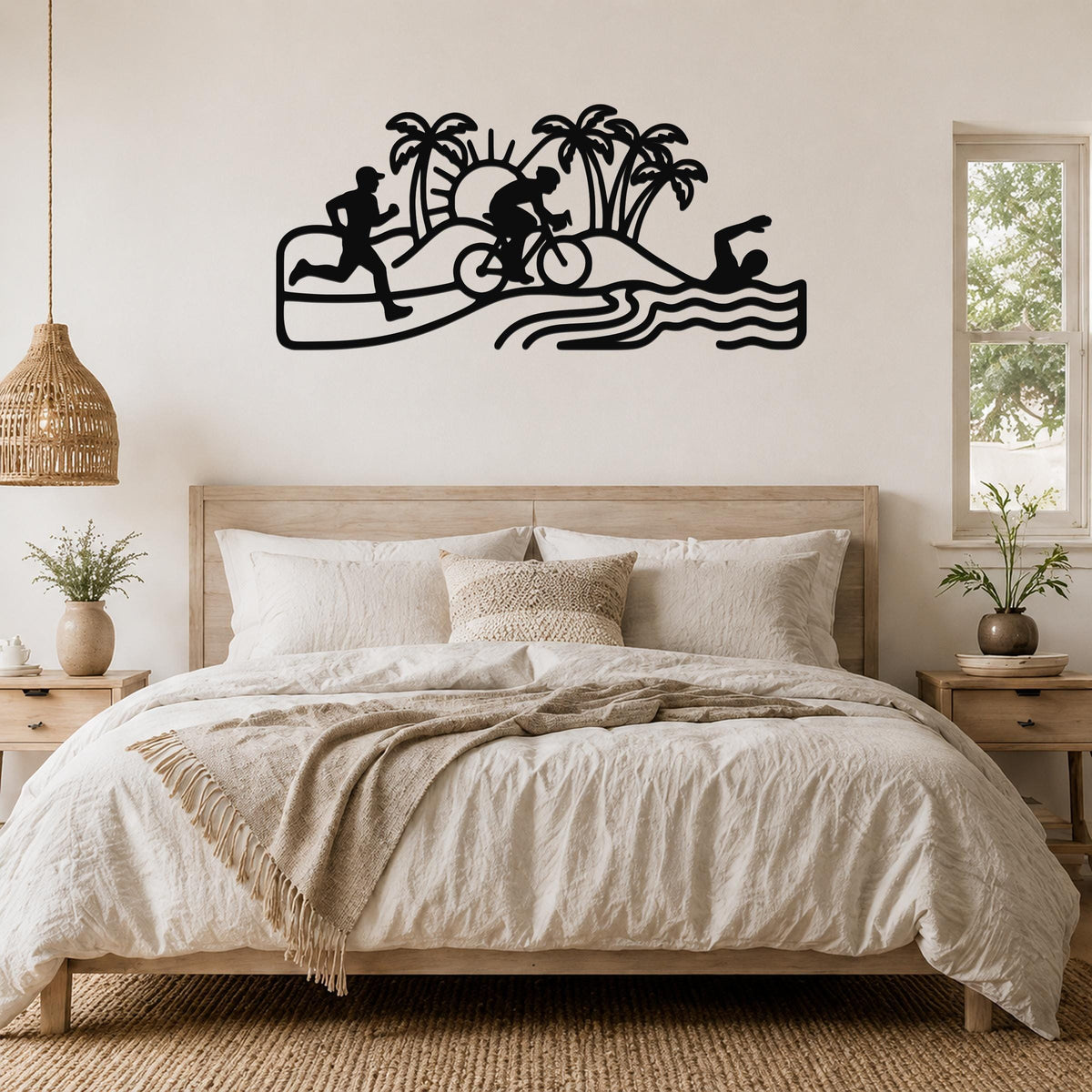 Black metal triathlon wall art with swim, bike, and run silhouettes, palm trees, and waves, mounted above a bed in a bedroom.