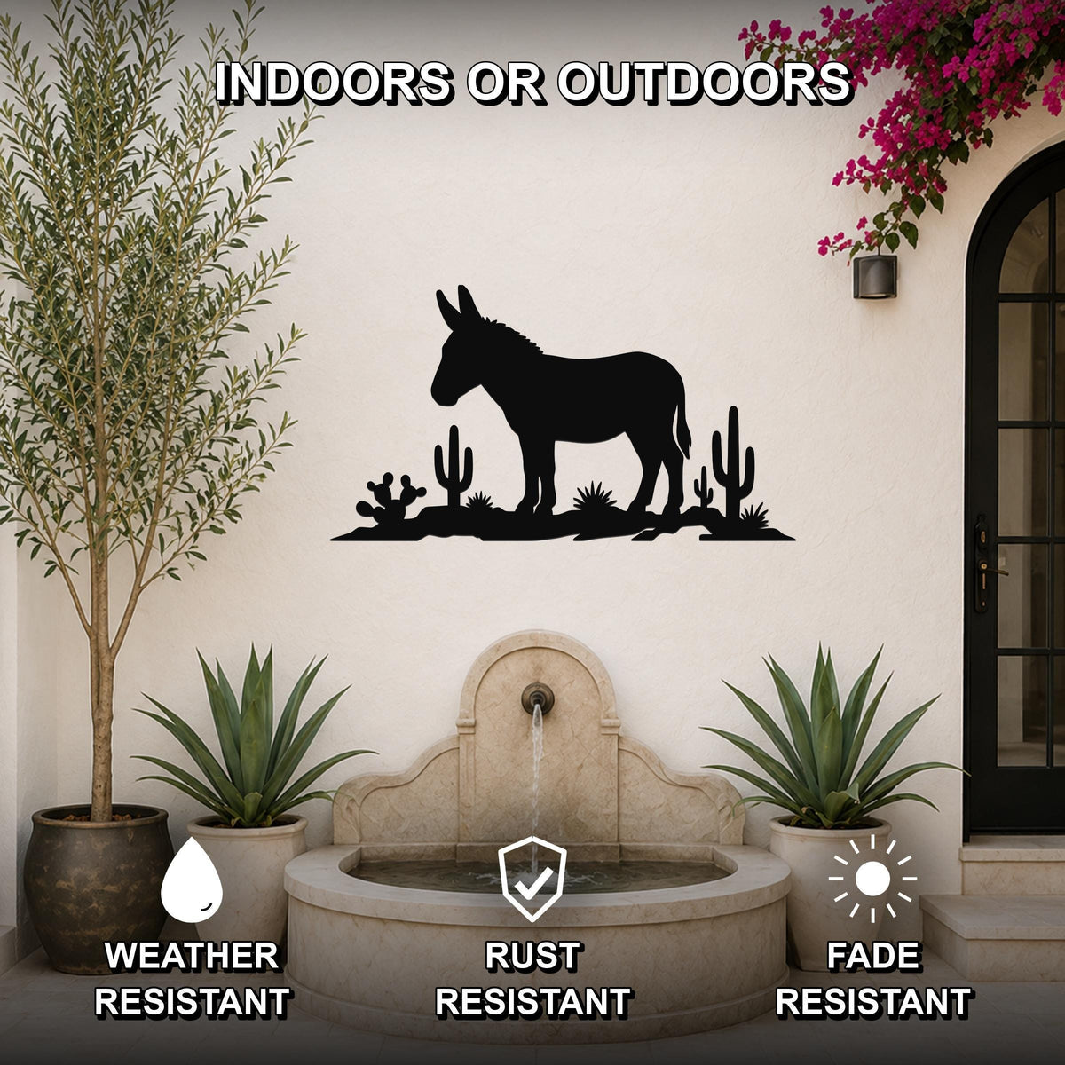 Black metal wall sculpture of a burro silhouette with cacti, mounted on an outdoor patio wall above a stone fountain.
