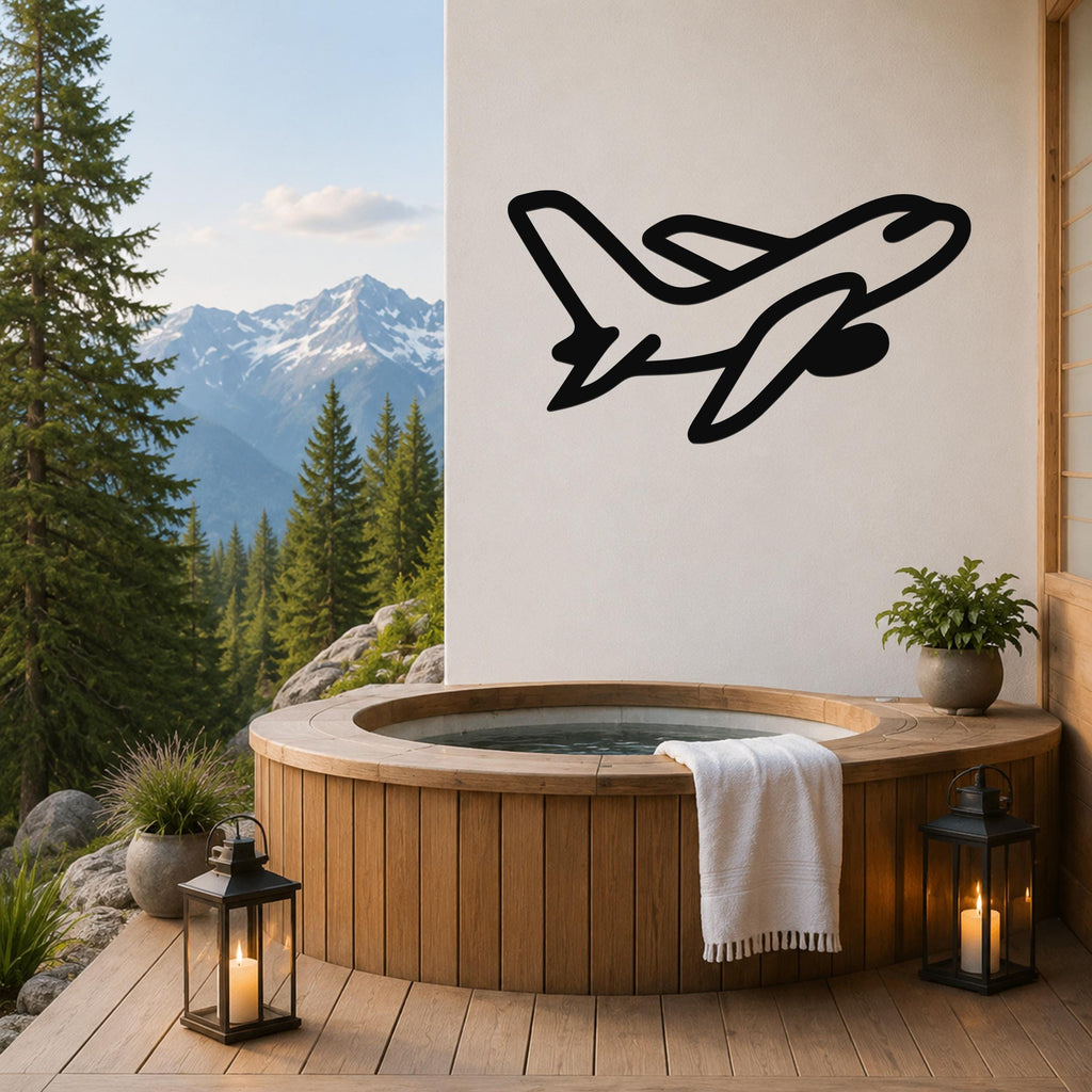 Black metal airplane wall art silhouette mounted on a white wall above a wooden hot tub on a mountain-view deck.