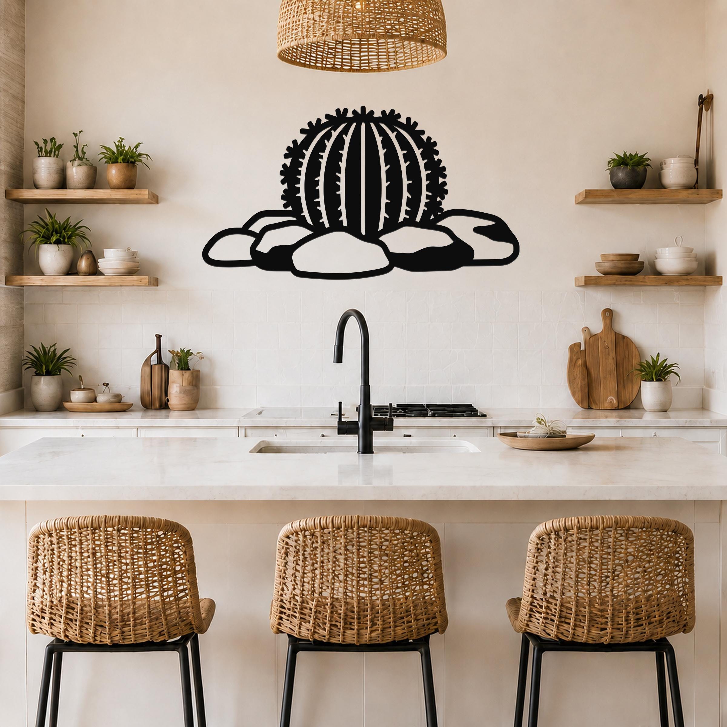 Black metal barrel cactus wall art with spines and rocks cutout, mounted above a kitchen counter.
