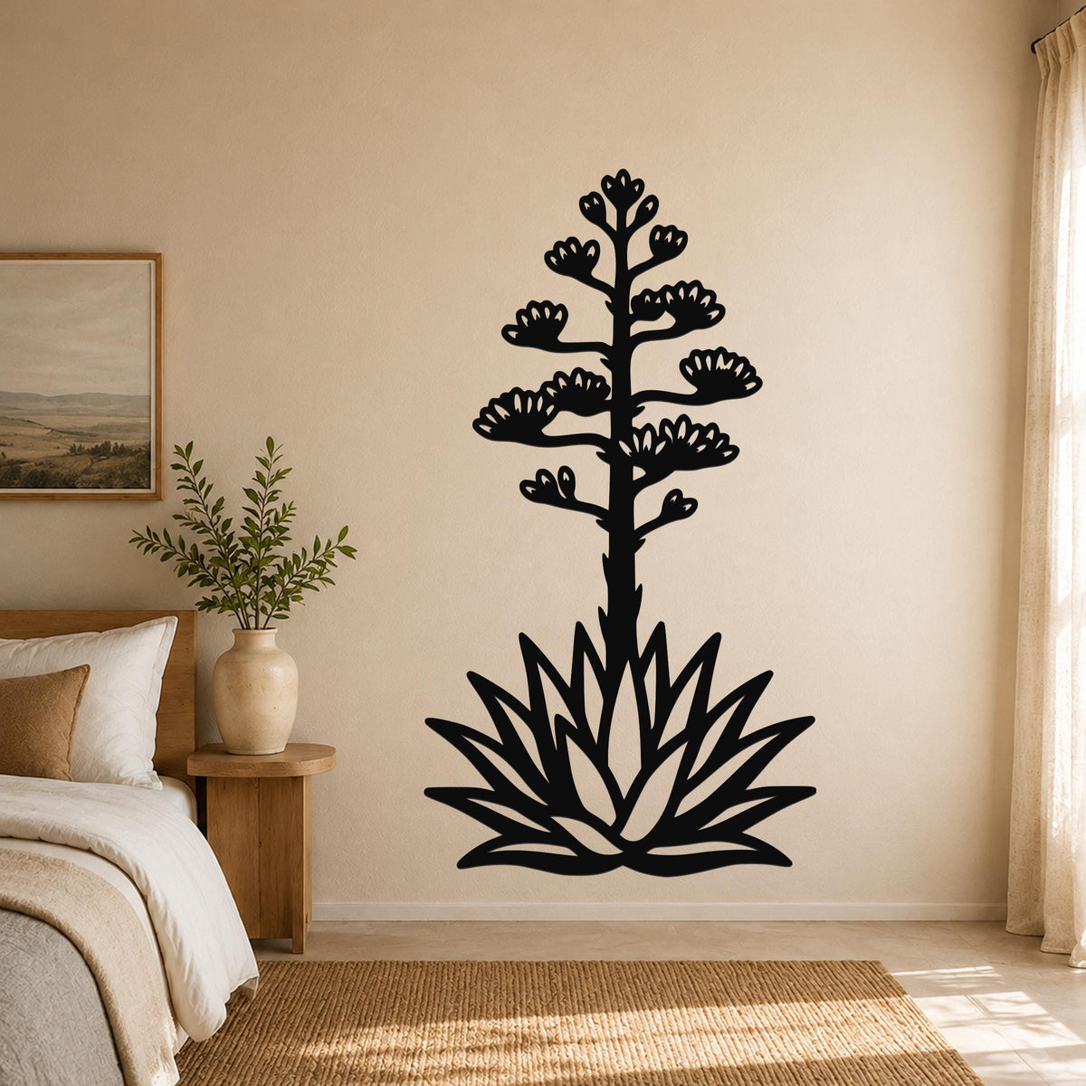 Black metal agave wall sculpture with blooming flower cutouts, mounted on a bedroom wall above a bed.