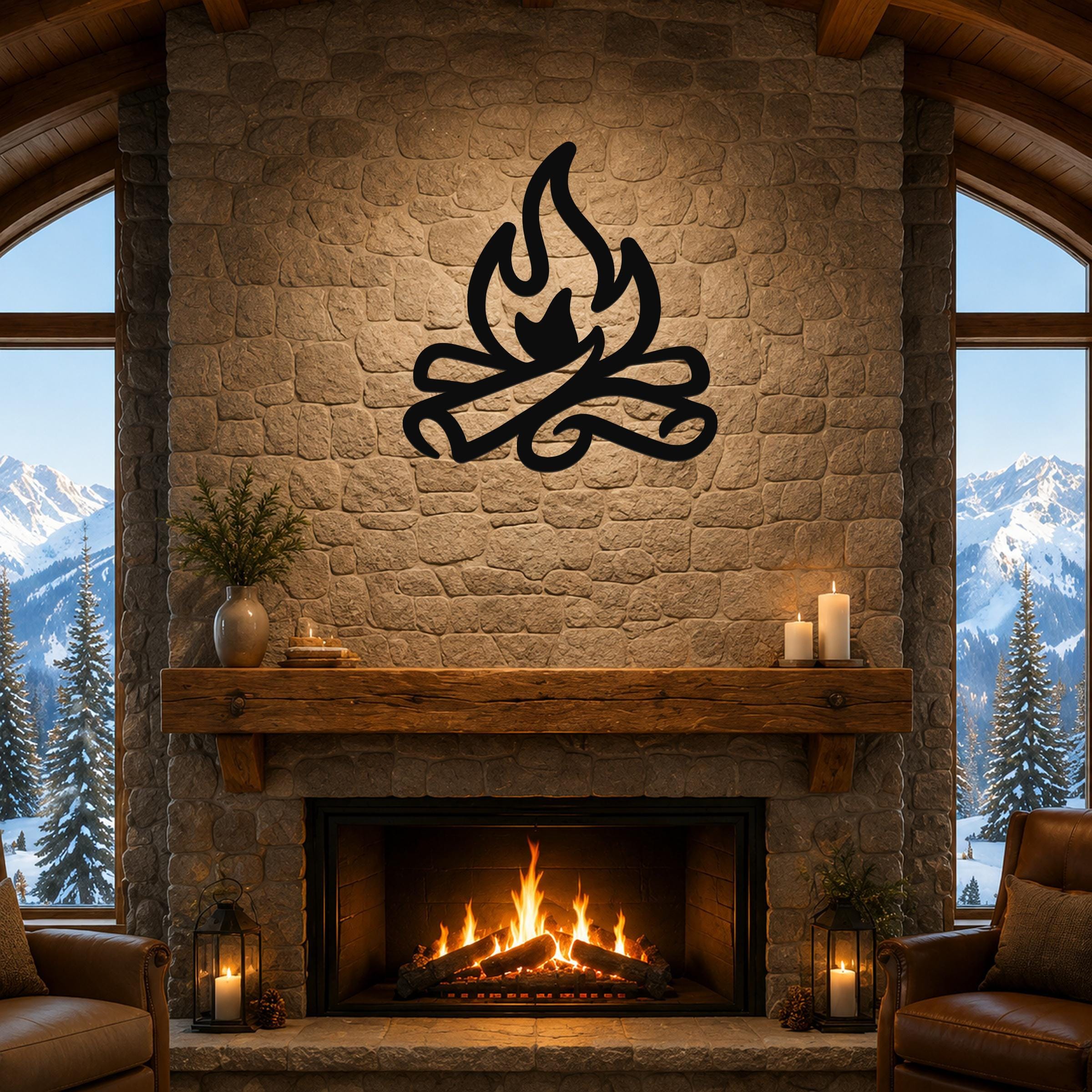 Black metal campfire wall art with flame and log silhouette, mounted above a stone fireplace in a rustic living room with mountain views.