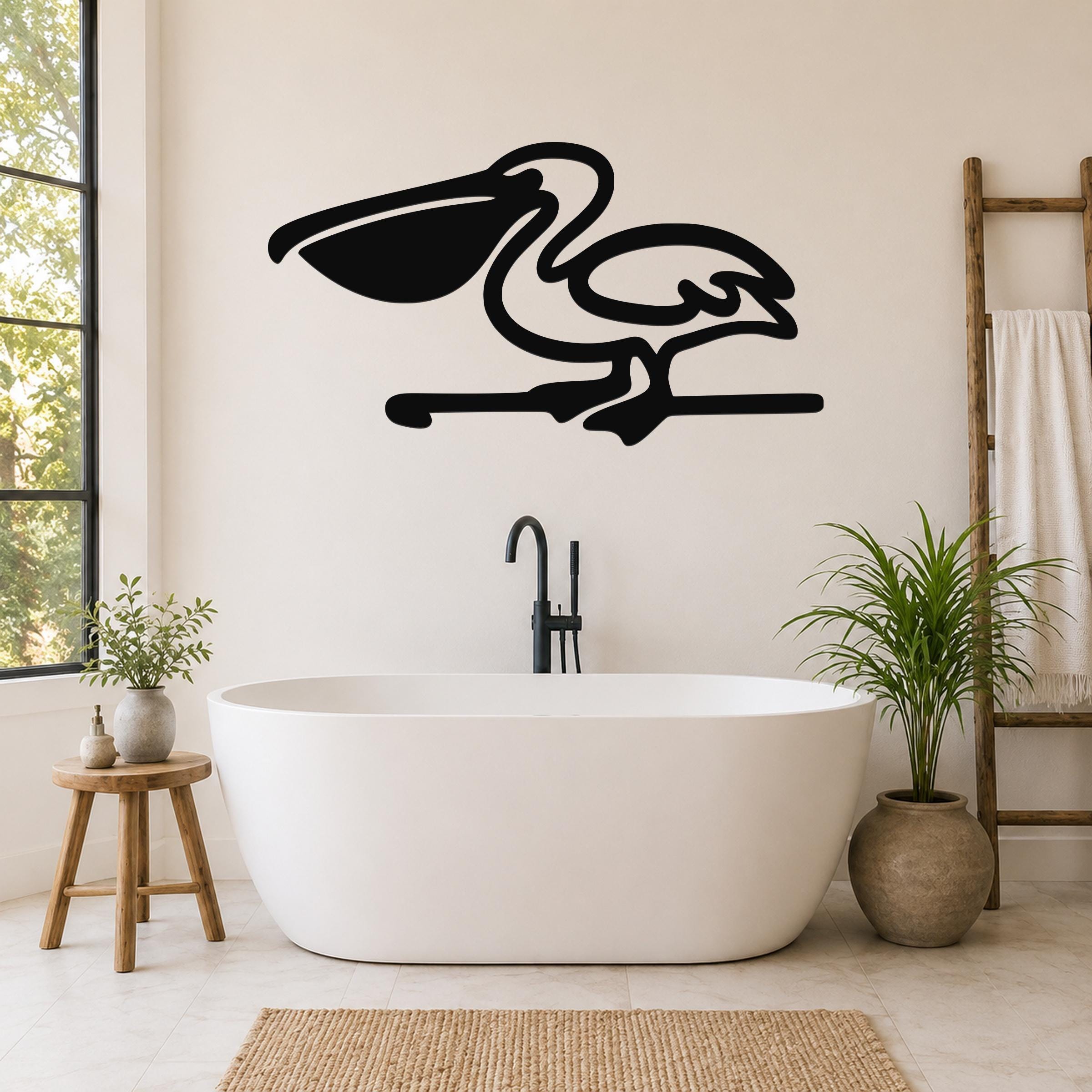 Black metal pelican wall art in silhouette style, mounted on a bathroom wall above a freestanding tub.