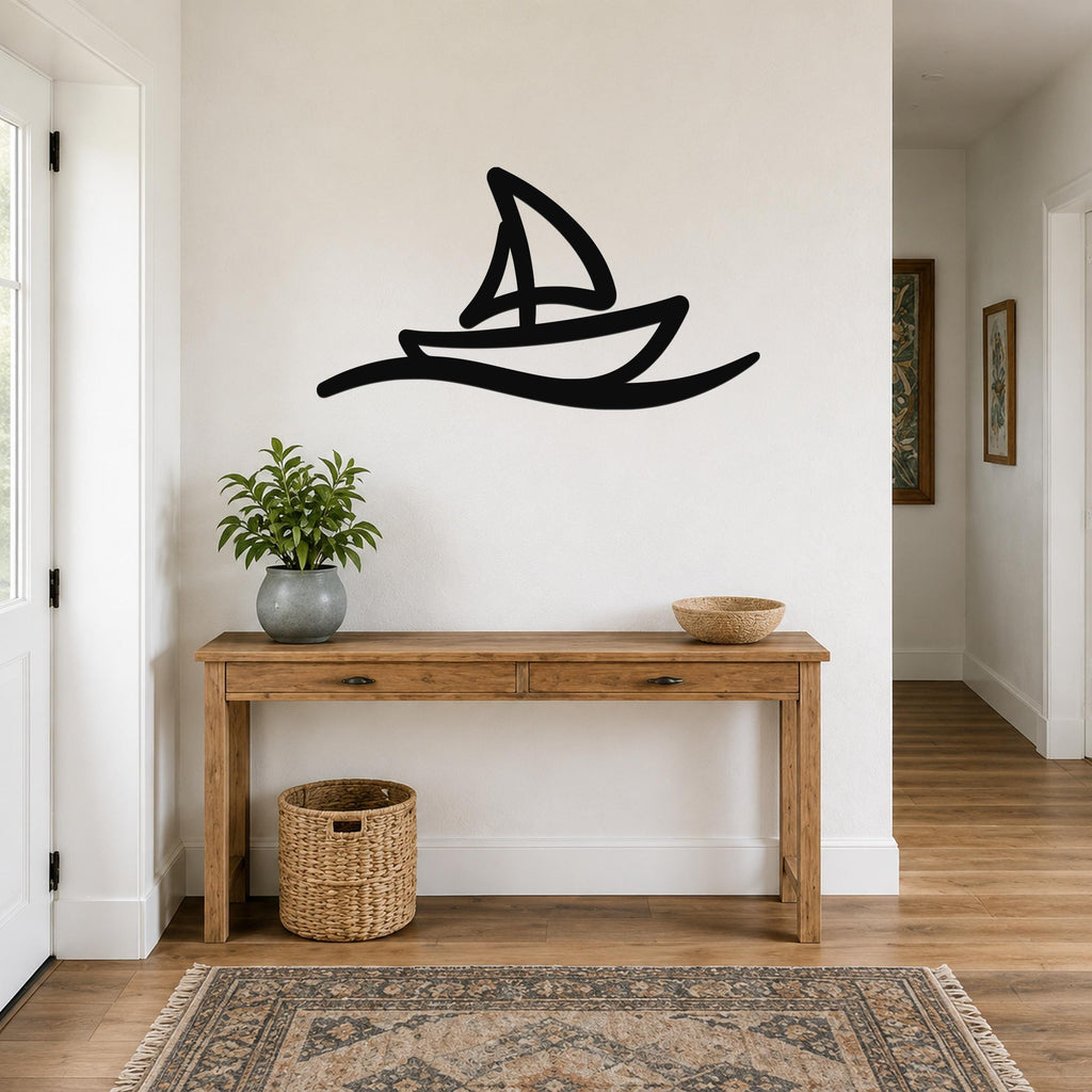 Black metal sailboat wall art with wave cutout, mounted above a wooden console table in a hallway.