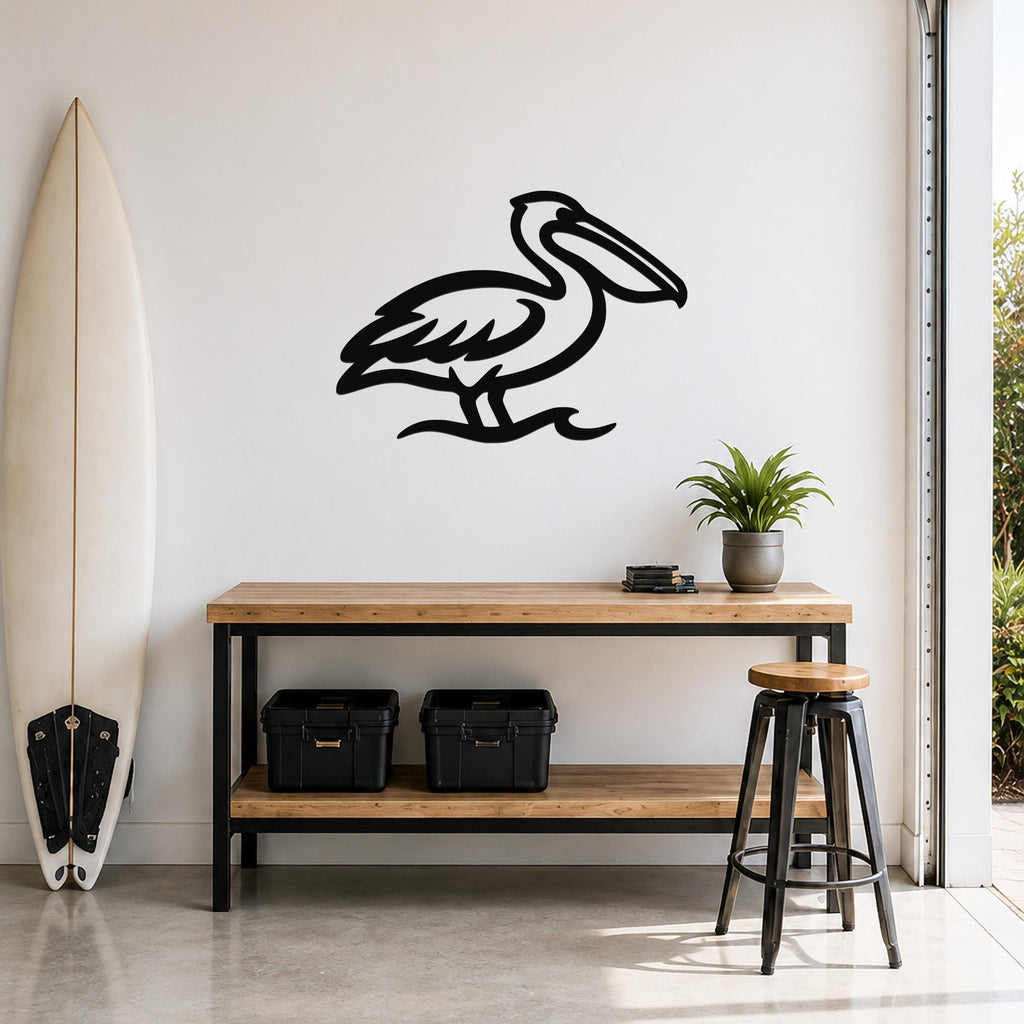 Black metal pelican wall art with a cutout silhouette, mounted on a white wall above a wooden counter in a coastal-style room.