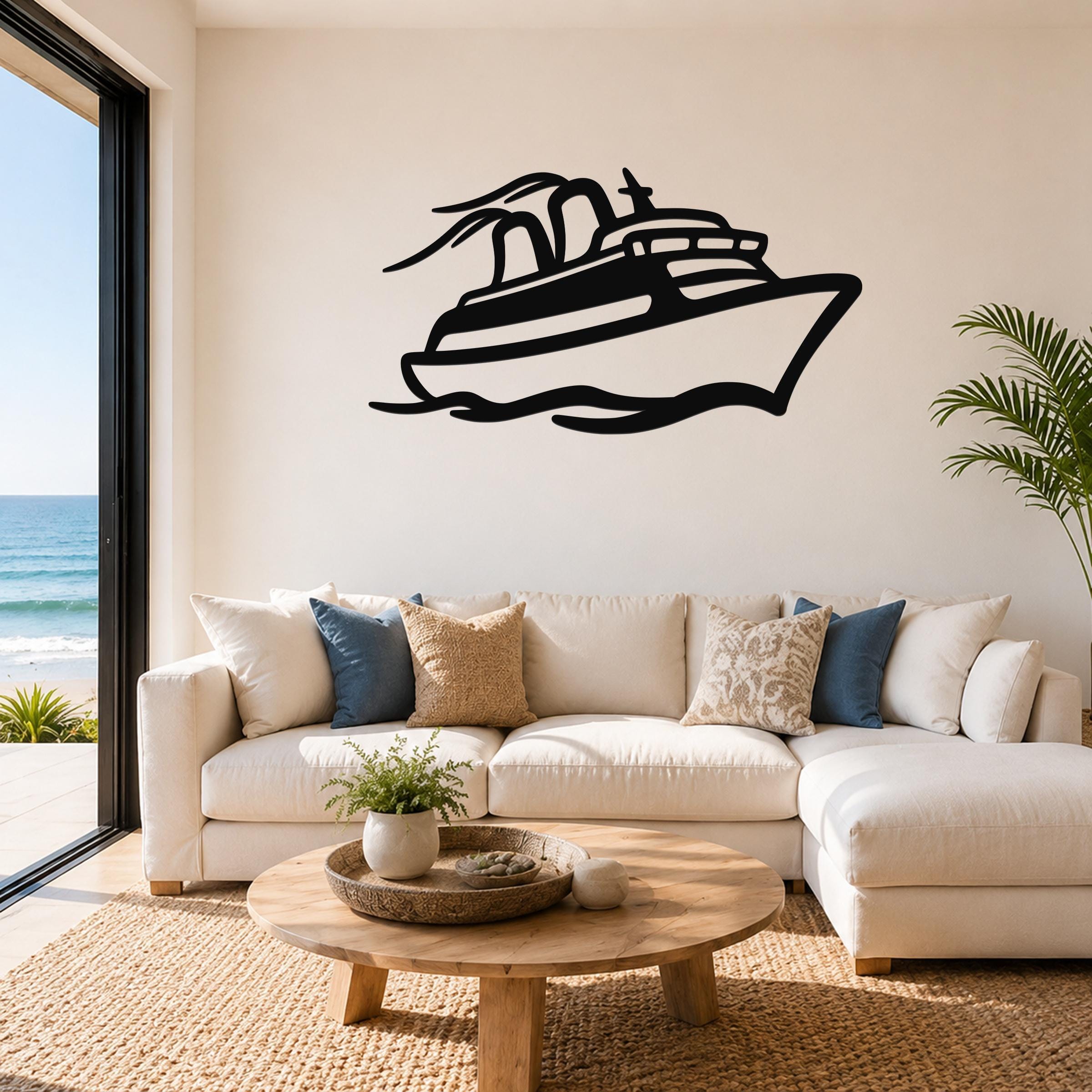Black metal cruise ship wall art with motion-line cutouts, mounted above a white sofa in a living room with ocean views.