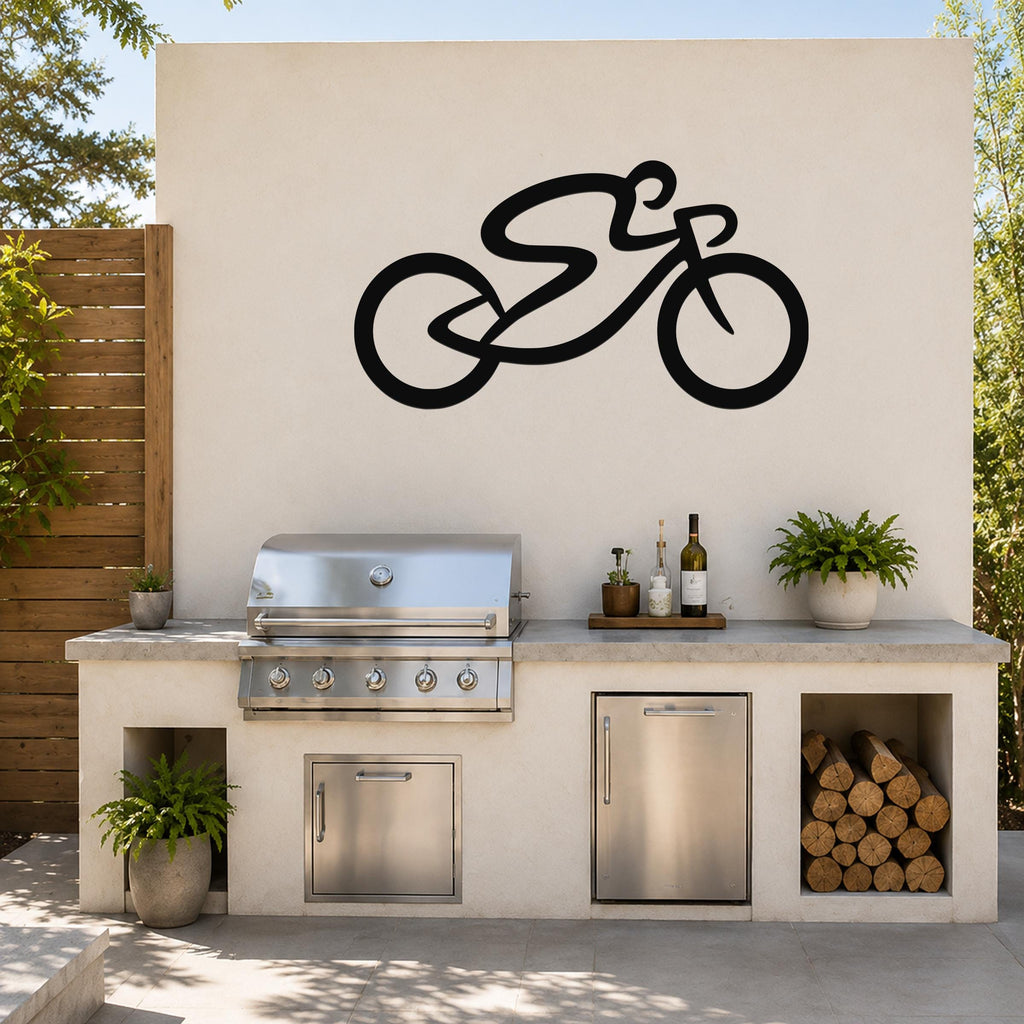 Black metal bicycle wall art with a bold silhouette design, mounted on an outdoor kitchen wall above a stainless steel grill and counter.