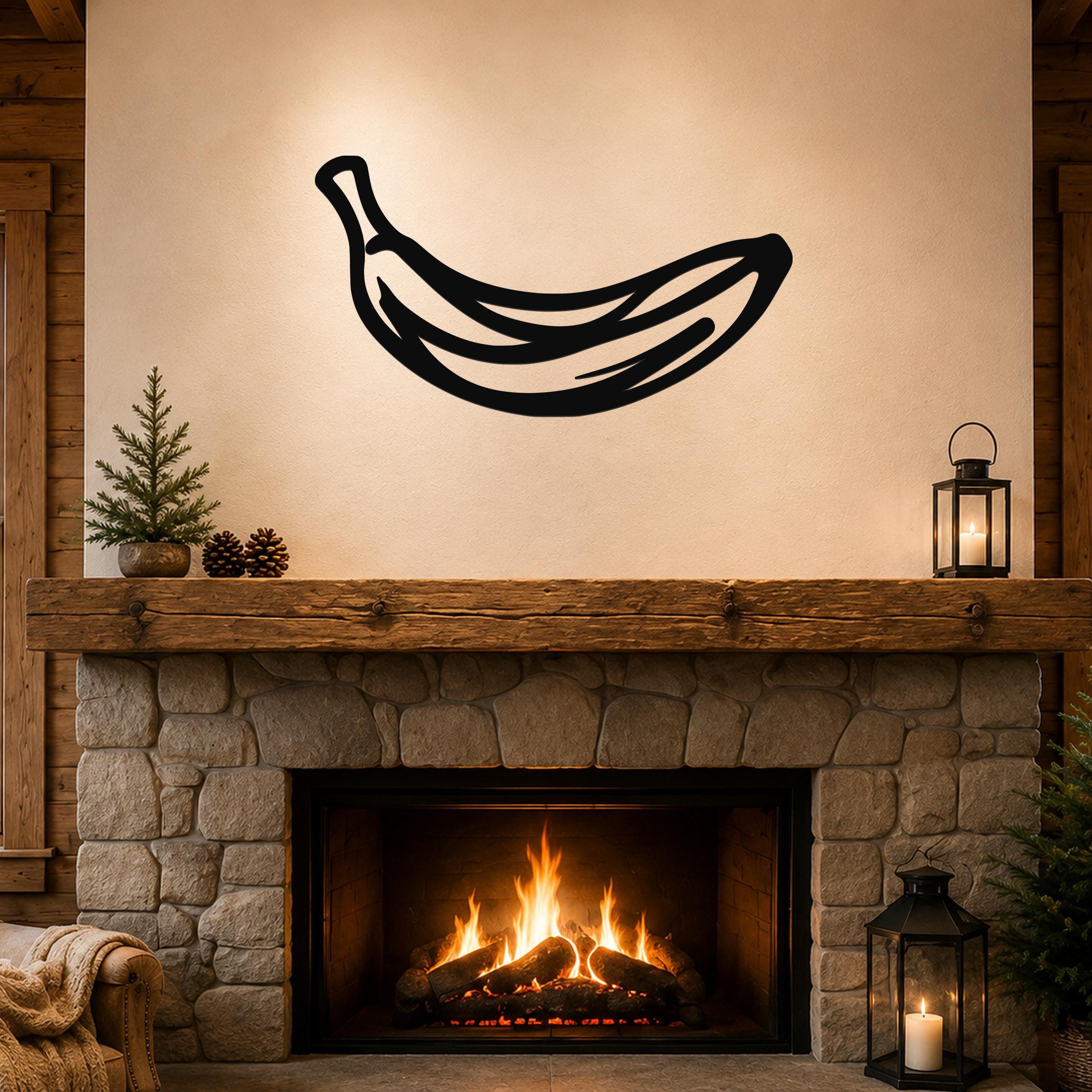 Black metal banana wall art with internal line cutouts, mounted above a stone fireplace in a rustic living room.