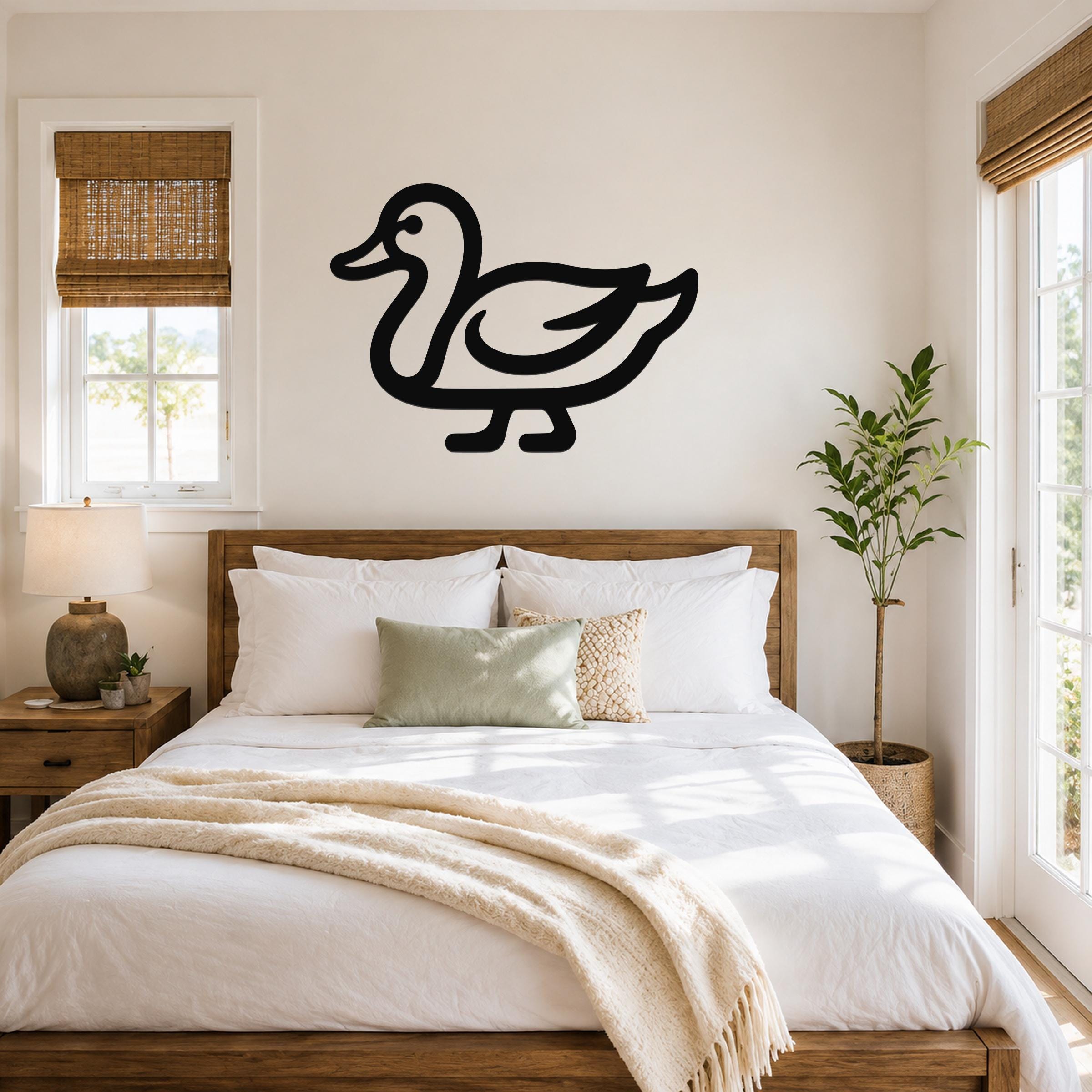 Black metal duck wall art silhouette mounted above a wooden bed in a bright bedroom.