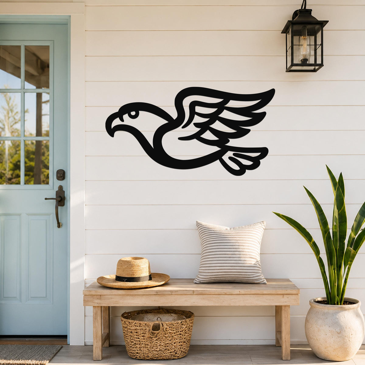 Black metal eagle wall art with a bold silhouette design, mounted on a white shiplap wall above a wooden bench in a porch entryway.