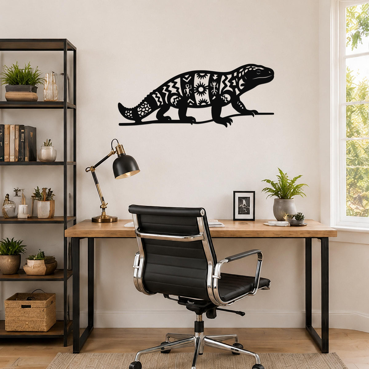 Black metal wall art of a Gila monster with intricate geometric and sunburst cutouts, mounted on a wall above a wooden desk in a home office.