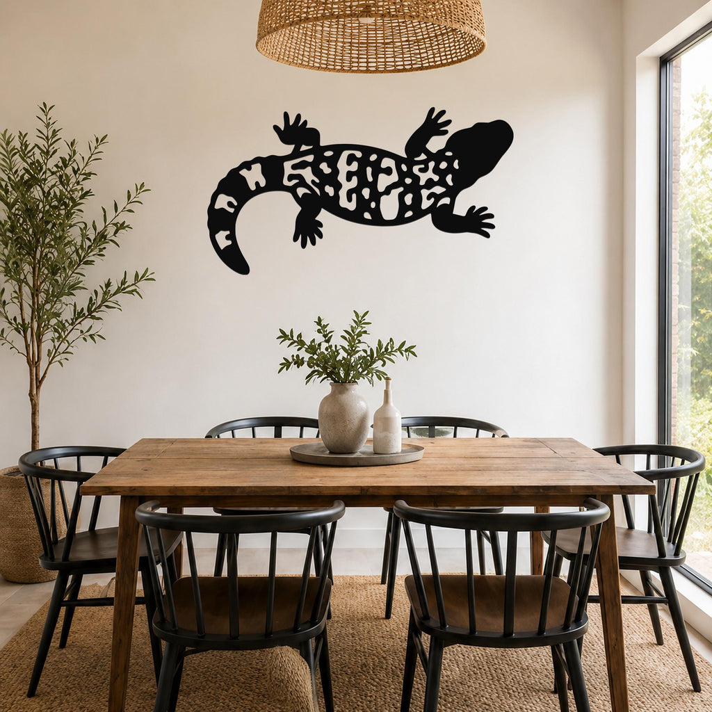 Black metal wall art of a Gila monster with intricate cutout patterns, mounted on a wall above a wooden dining table in a bright, modern dining room.