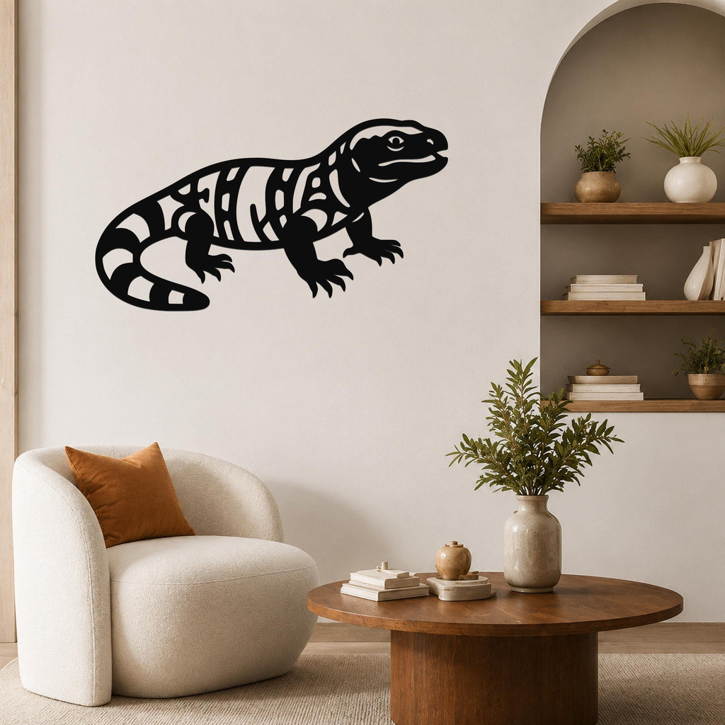Black metal Gila monster wall art with intricate internal cutouts, mounted on a living room wall above a white armchair.