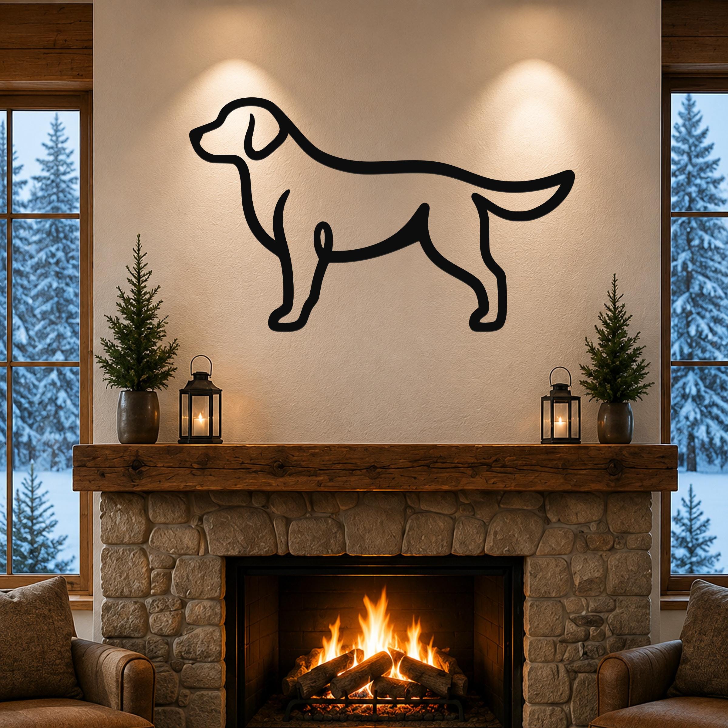 Black metal dog silhouette wall art mounted above a stone fireplace in a cozy living room with snow outside.