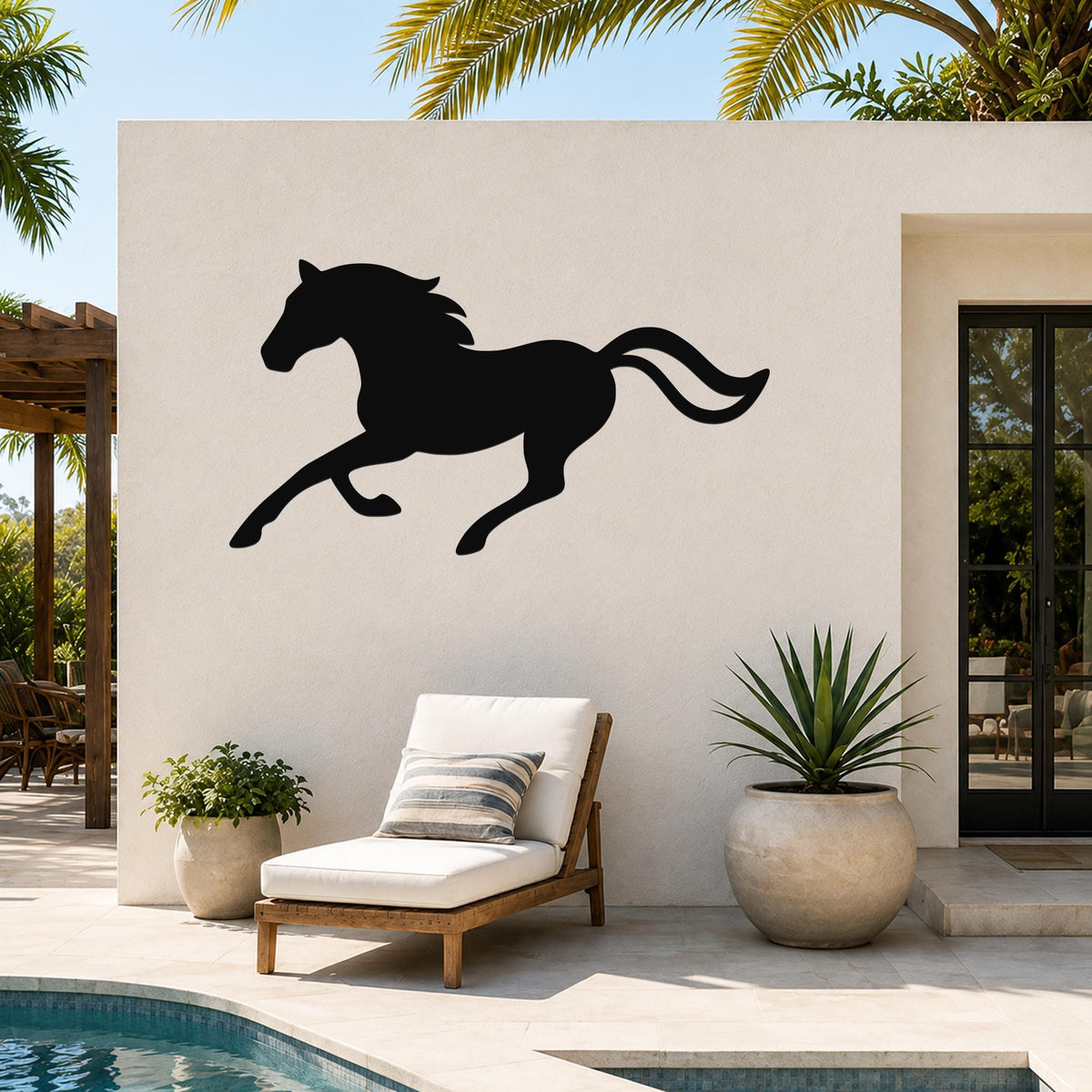 Black metal horse wall art silhouette with flowing mane and tail, mounted on an outdoor patio wall above a lounge chair near a pool.
