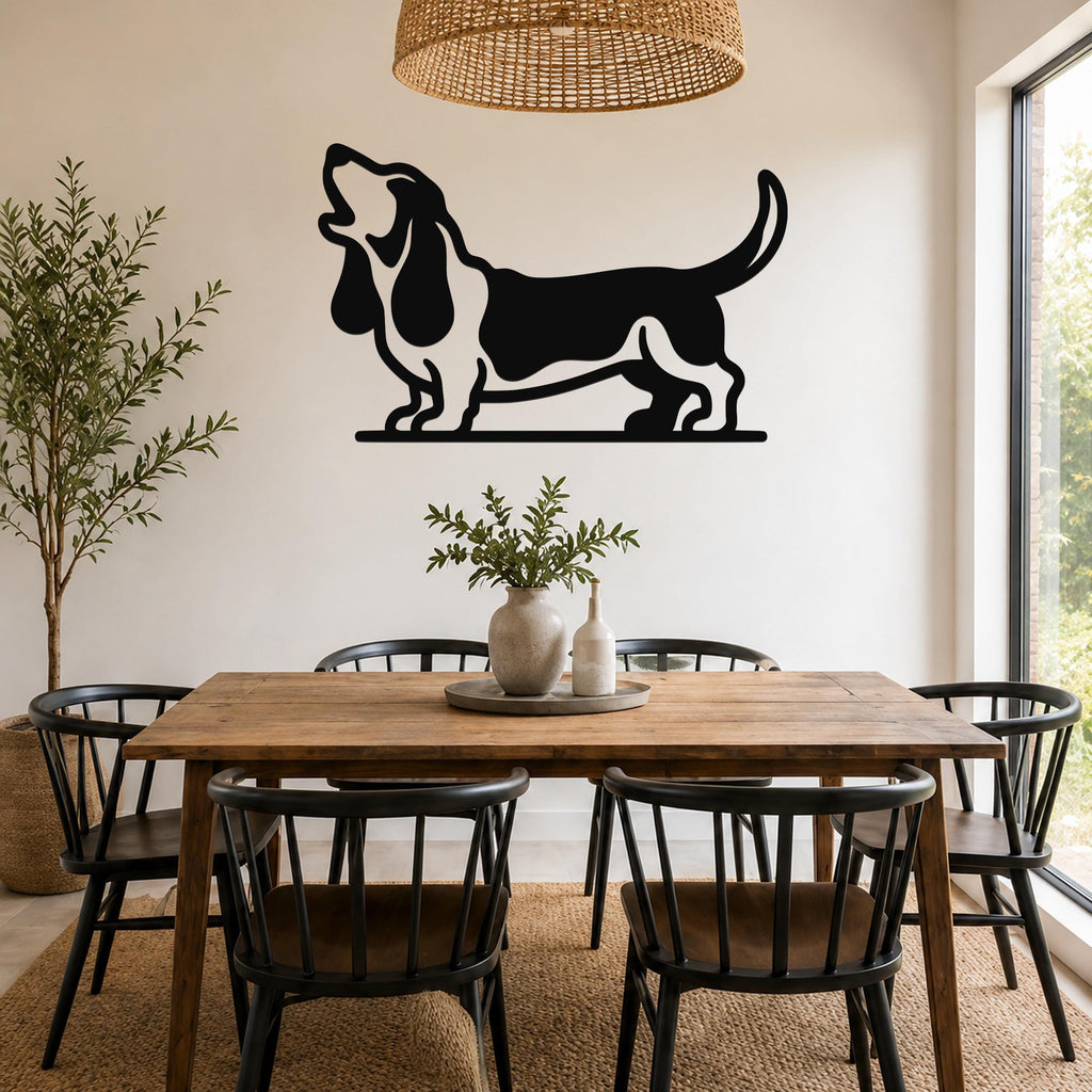 Black metal wall art of a howling basset hound silhouette, mounted on a wall above a wooden dining table in a bright room.
