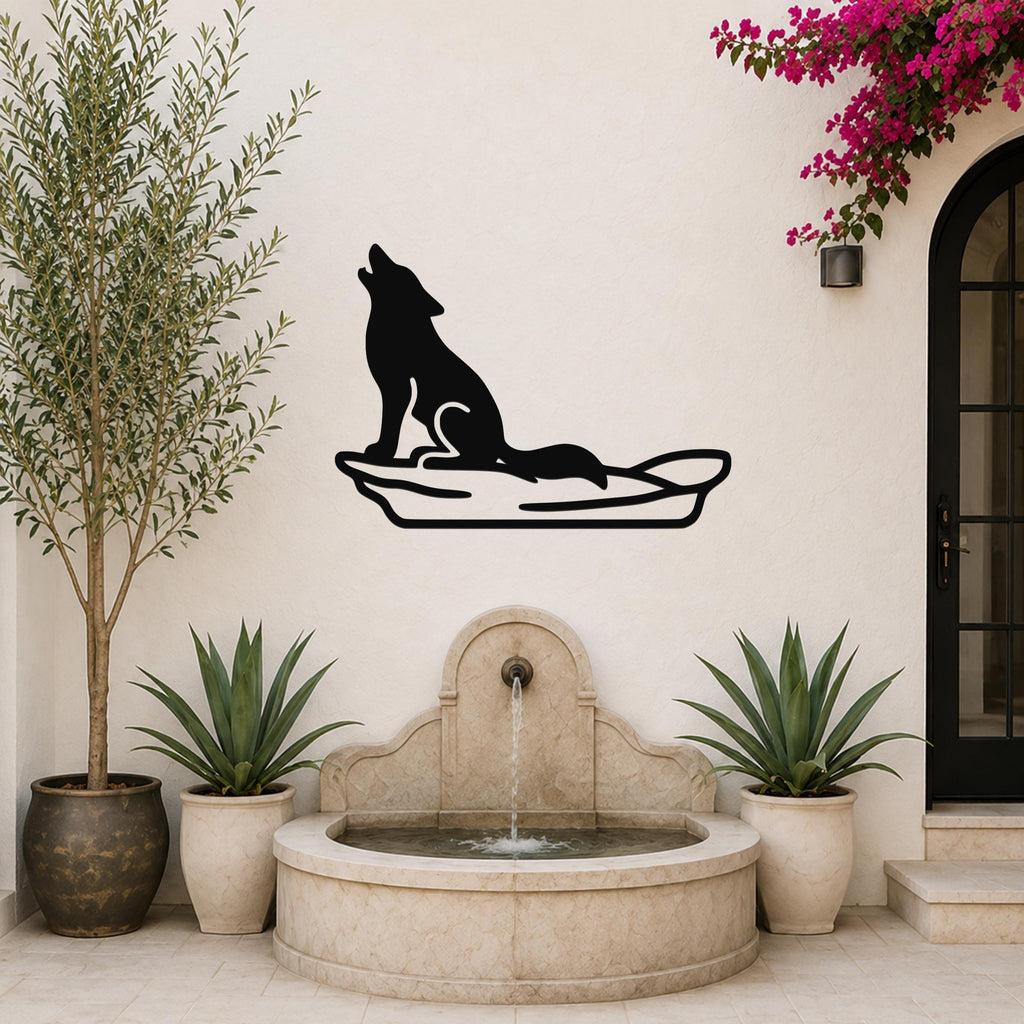 Black metal coyote wall art in a howling silhouette, mounted on a white outdoor wall above a stone fountain with potted plants.
