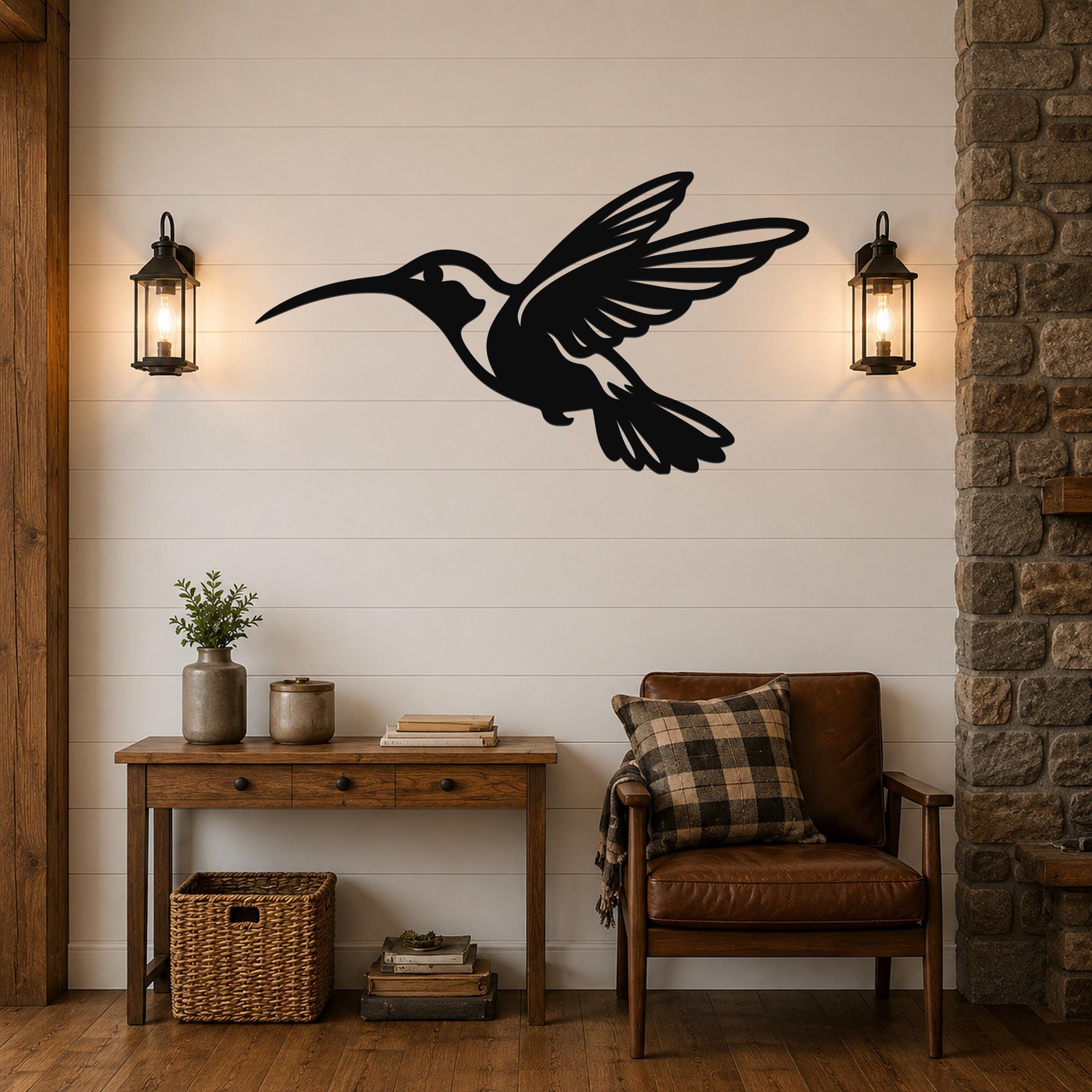Black metal hummingbird wall art with wing and tail cutouts, mounted on a shiplap wall above a wooden console table in a living room.