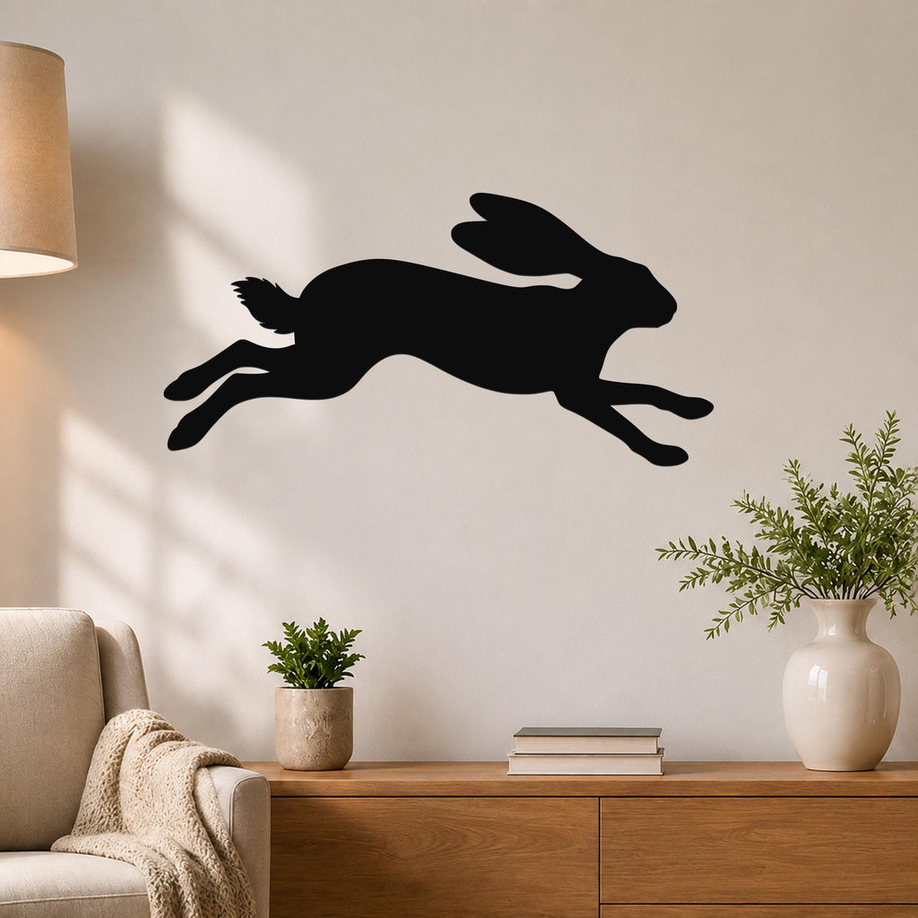 Black metal jackrabbit wall art silhouette with motion lines, mounted on a living room wall above a wooden console table.