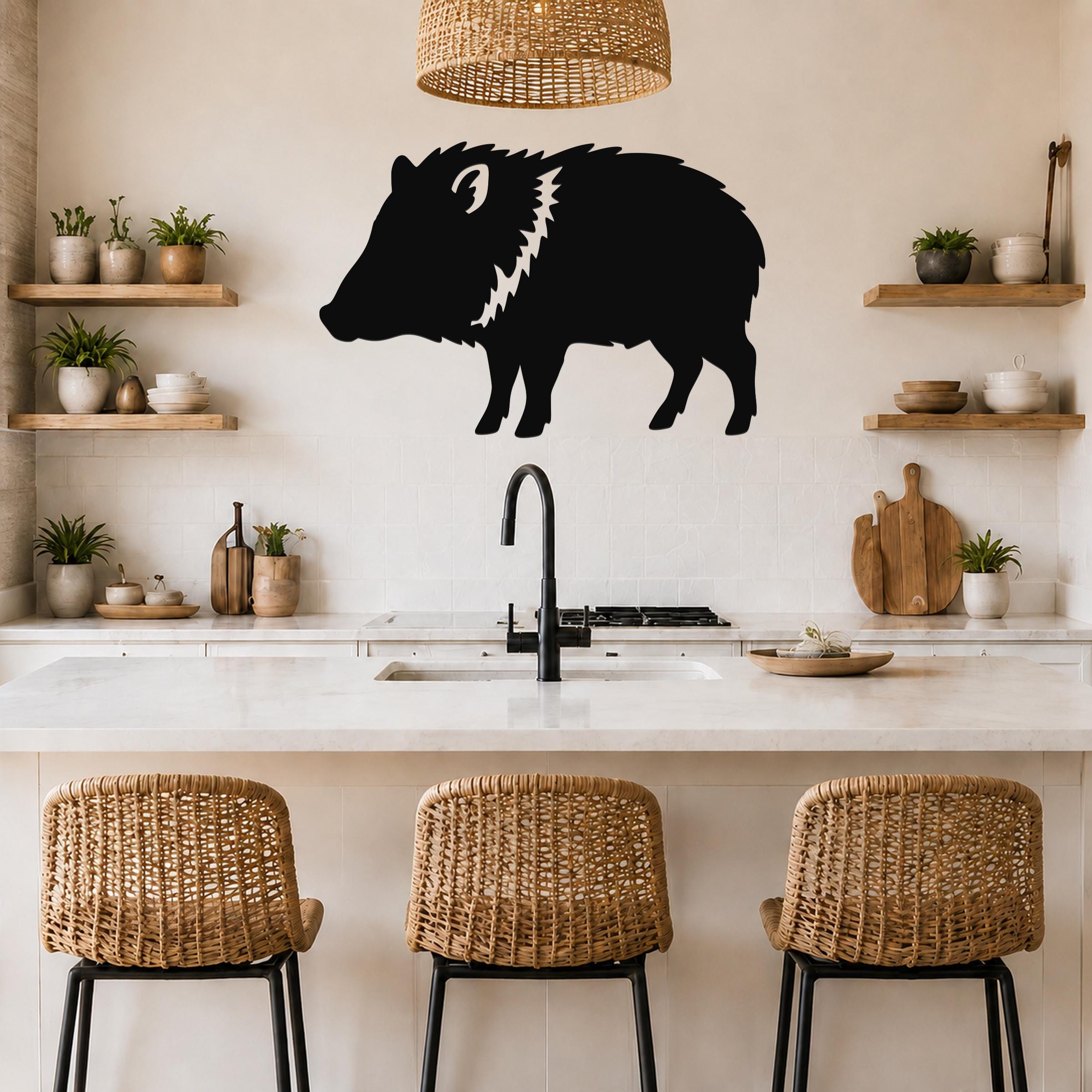 Black metal javelina wall art silhouette with white cutout details, mounted on a kitchen wall above a counter.