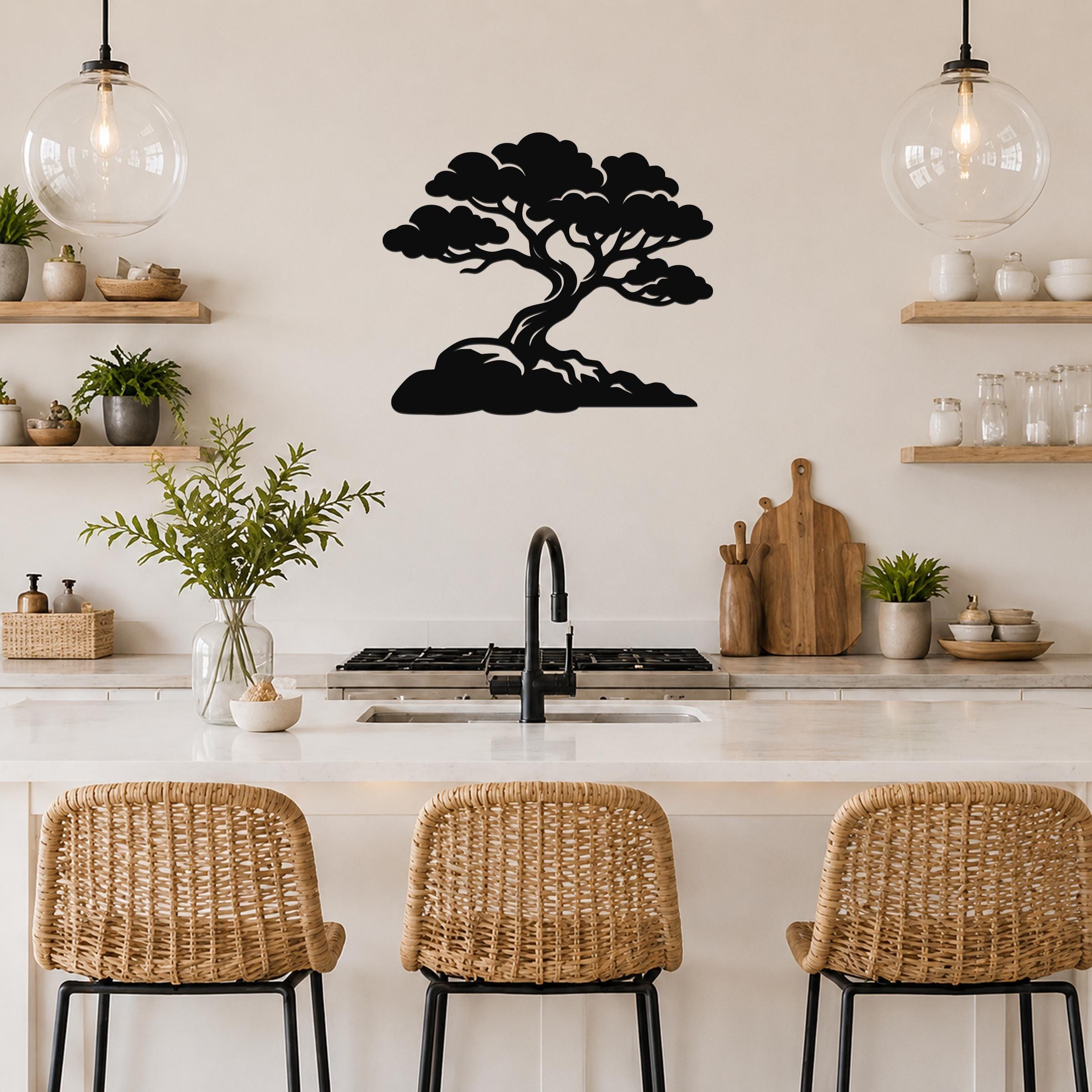 Black metal wall art in a bonsai tree silhouette, mounted on a kitchen wall above a counter with wicker bar stools.