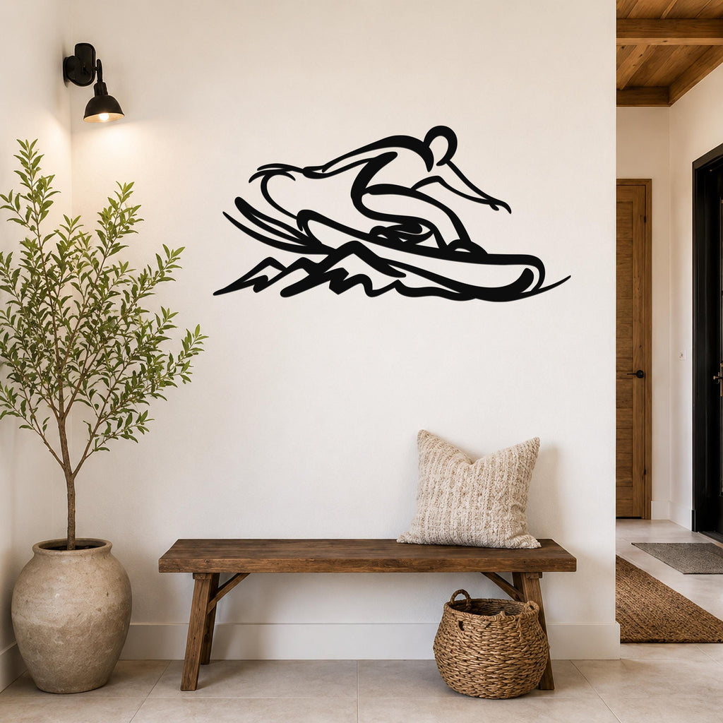 Black metal wall art silhouette of a snowboarder in motion, mounted on a white wall above a wooden bench in a hallway.
