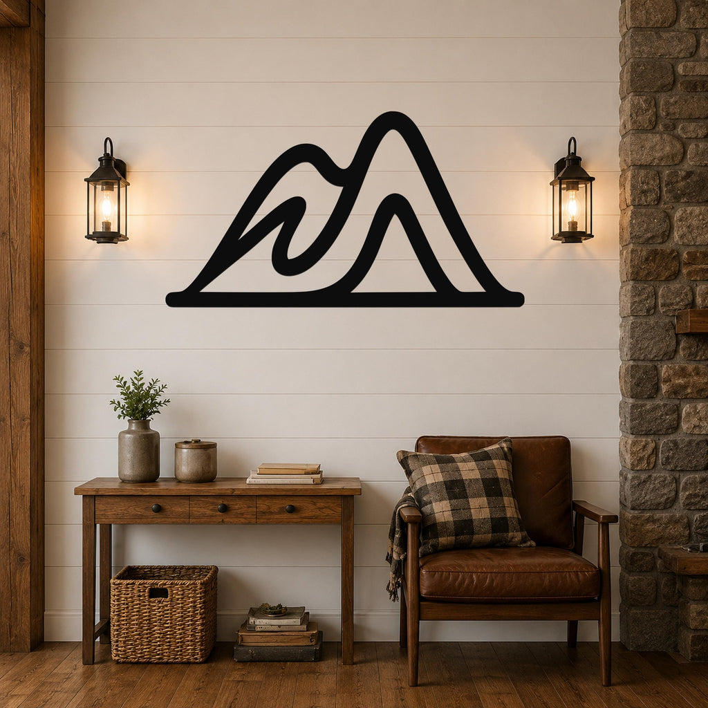 Black metal mountain silhouette wall art with layered peaks, mounted on a shiplap wall above a wooden console table in a rustic living room.