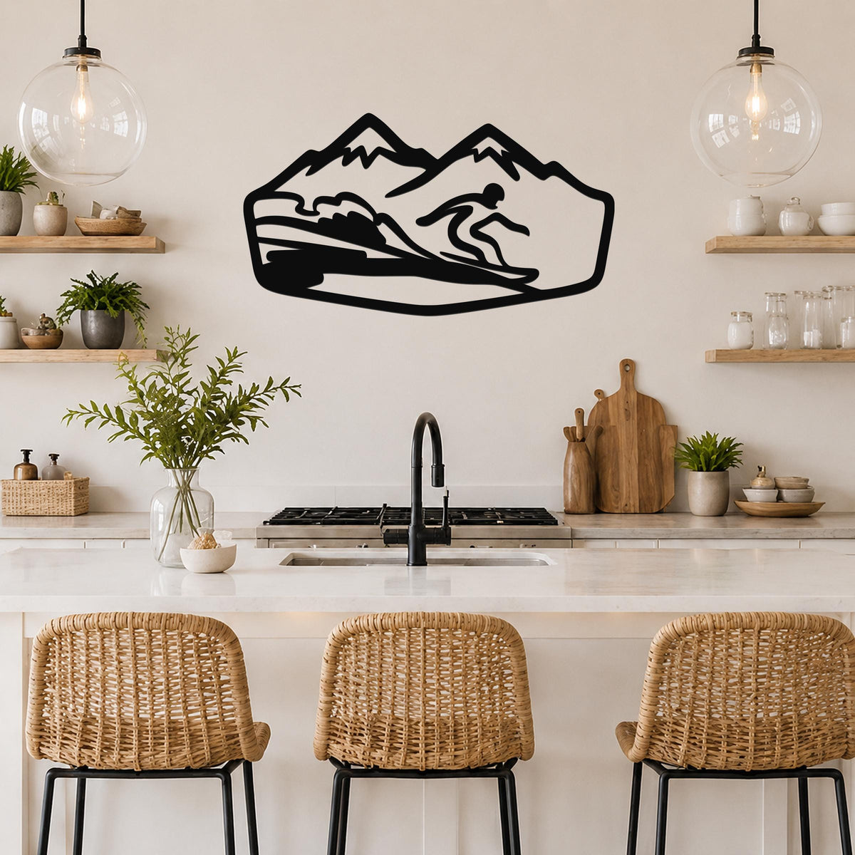 Black metal wall art with a snowboarder silhouette riding a wave, mounted above a kitchen counter between two glass pendant lights.