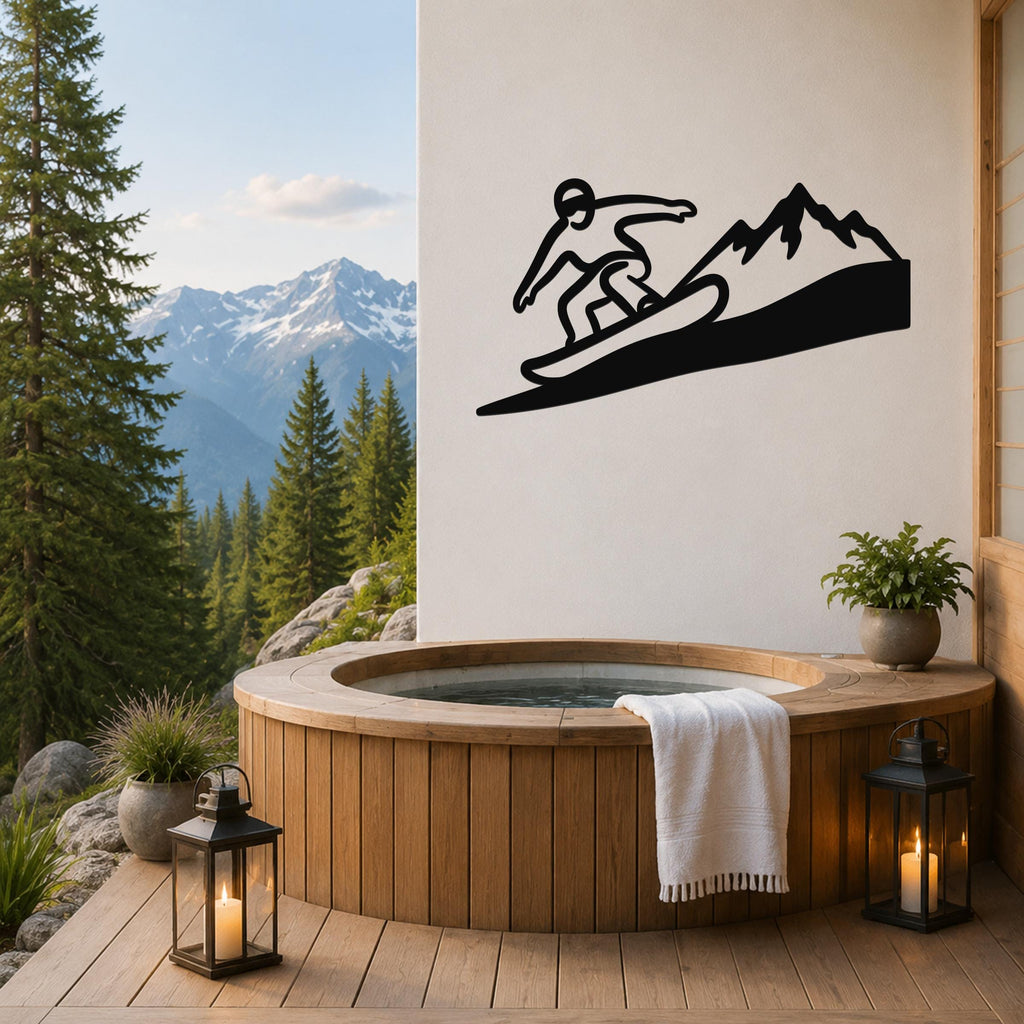 Black metal wall art featuring a snowboarder silhouette on a mountain slope, mounted on a white wall above a wooden hot tub on a deck with mountain views.