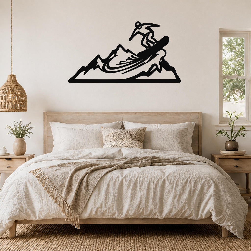 Black metal wall art cutout of a snowboarder on a mountain, mounted above a bed in a bedroom.
