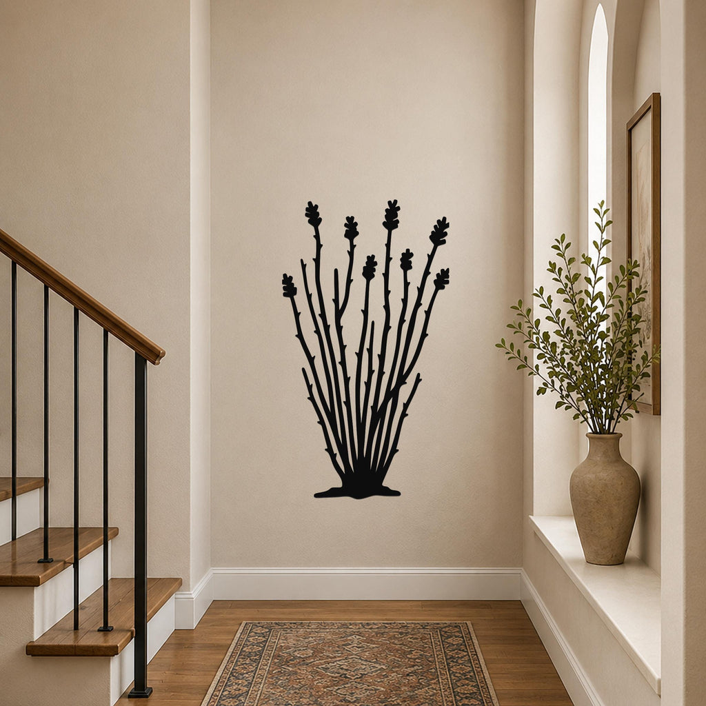 Black metal ocotillo wall art with branching stems and flower cutouts, mounted on a hallway wall above a patterned rug.