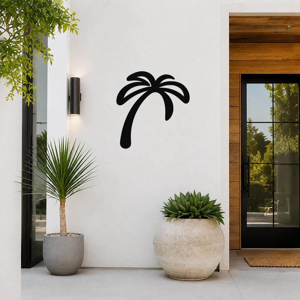Black metal palm tree wall art with a silhouette design, mounted on a white exterior wall beside a glass door and potted plants.