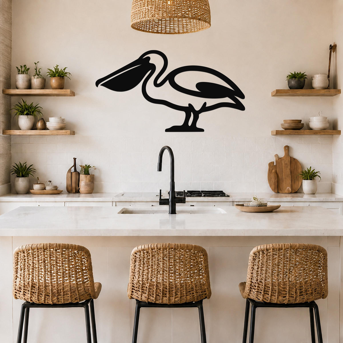 Black metal pelican wall art silhouette mounted above a kitchen counter, displayed in a coastal-style kitchen with wicker chairs and wooden shelves.