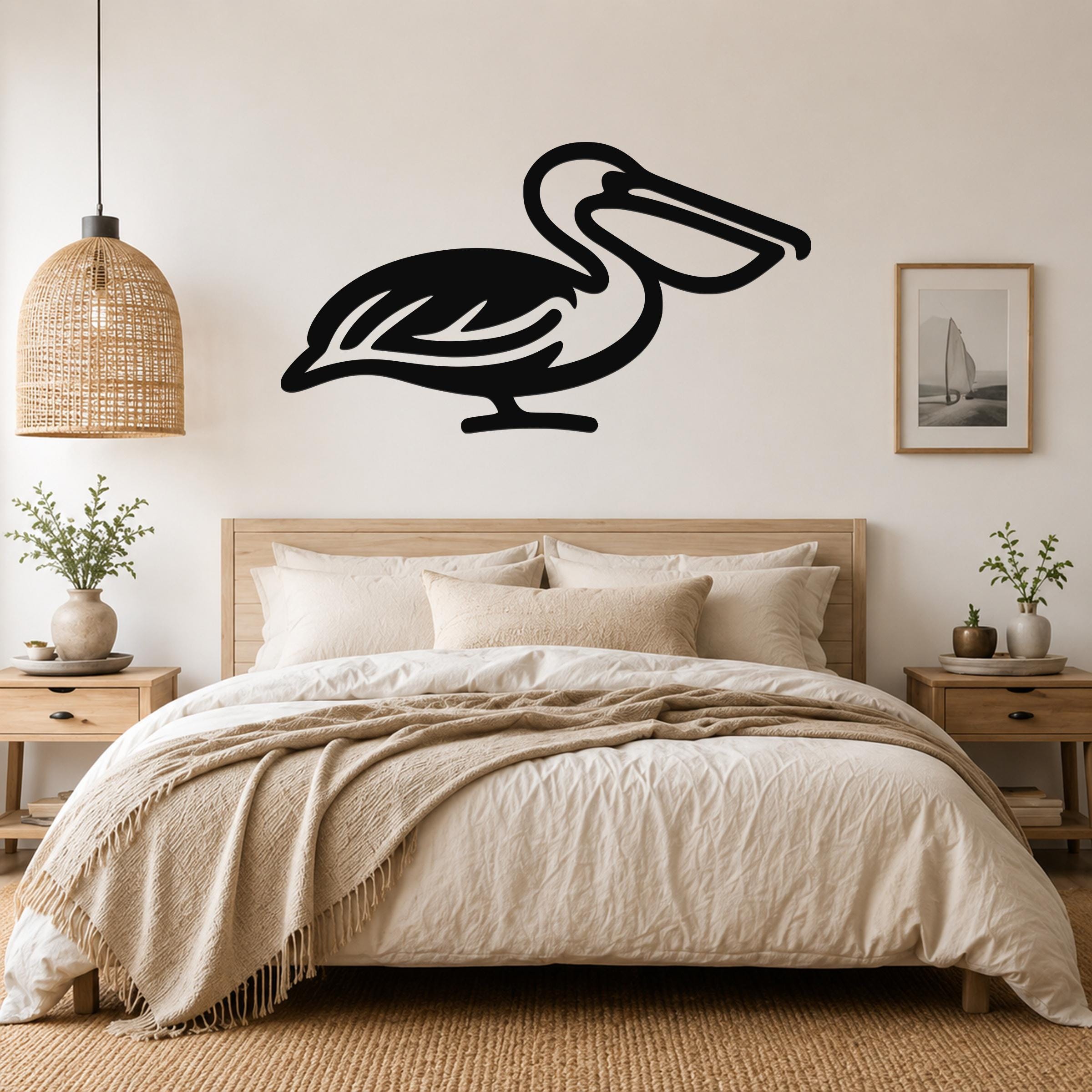 Black metal pelican wall art silhouette mounted above a bed in a neutral bedroom.